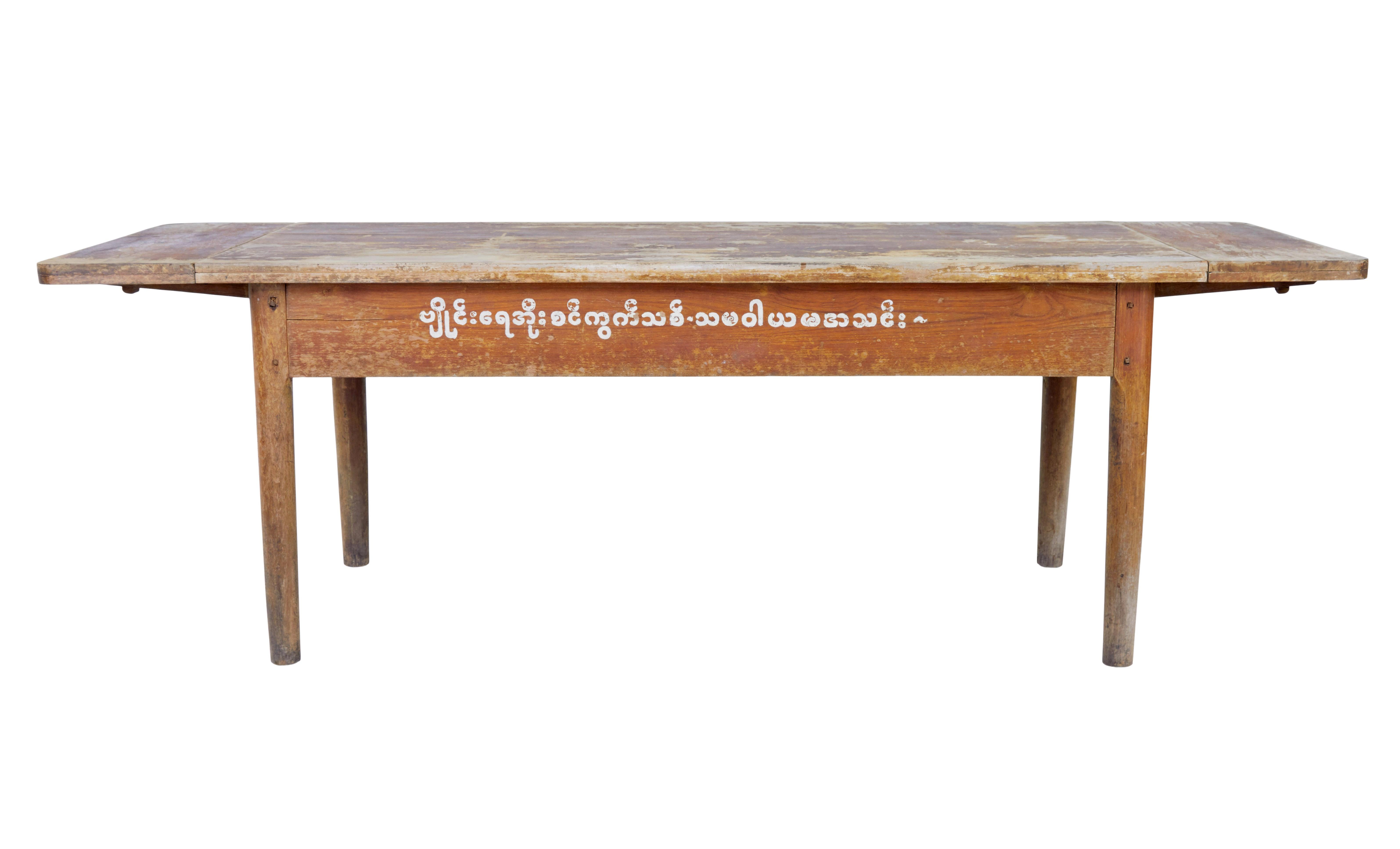 19th century burmese painted teak village table circa 1890.

Rare table from myanmar (formerly burma) .  This table was from a village where the elders would gather round to discuss local issues.  Hand painted on the side, which roughly translates