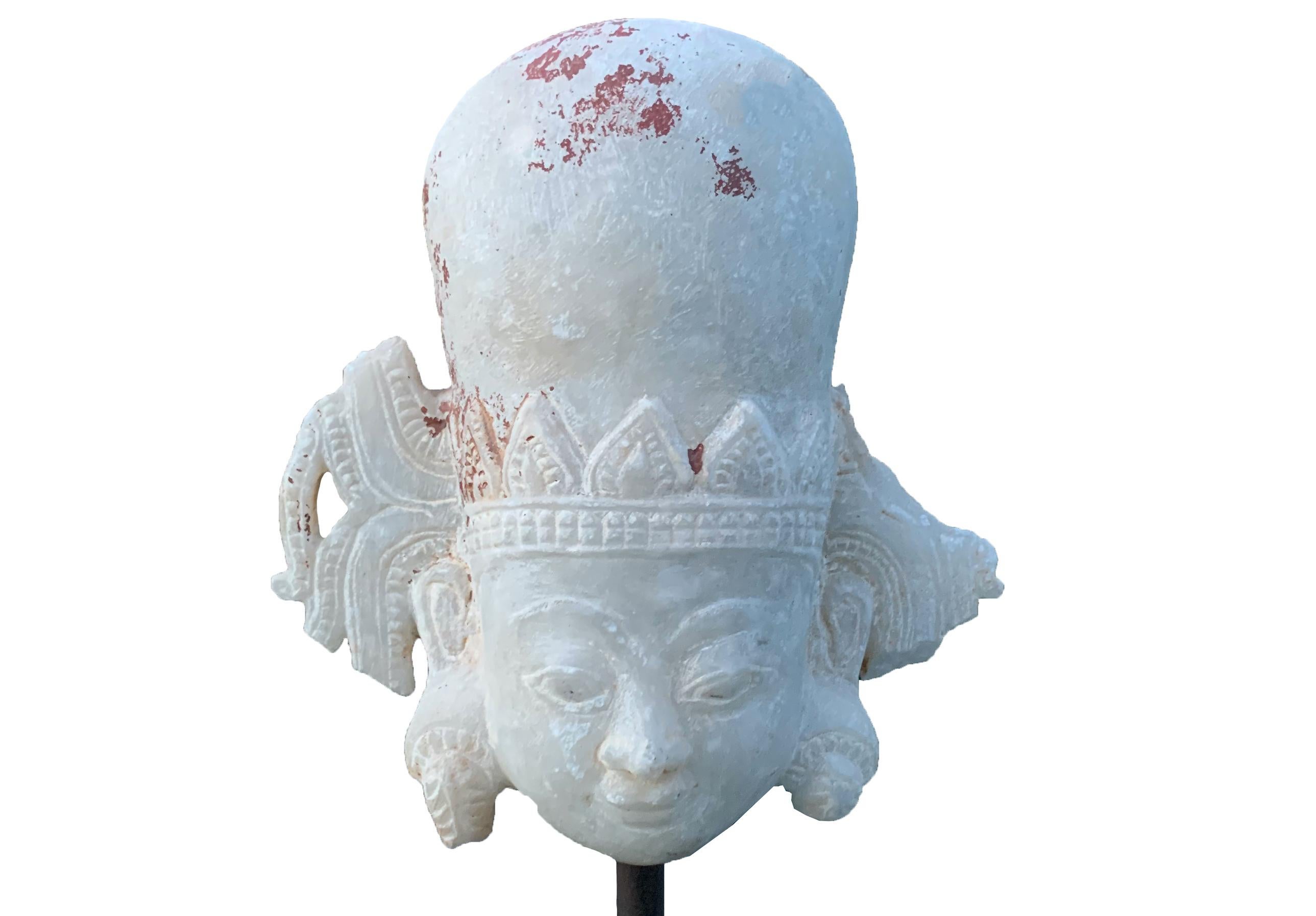 This small marble head of the Buddha is from the Shan States of Burma and carved from white marble. The face is framed by elongated and intricately carved ears. There are faint signs of the original burgundy and black lacquer which has almost