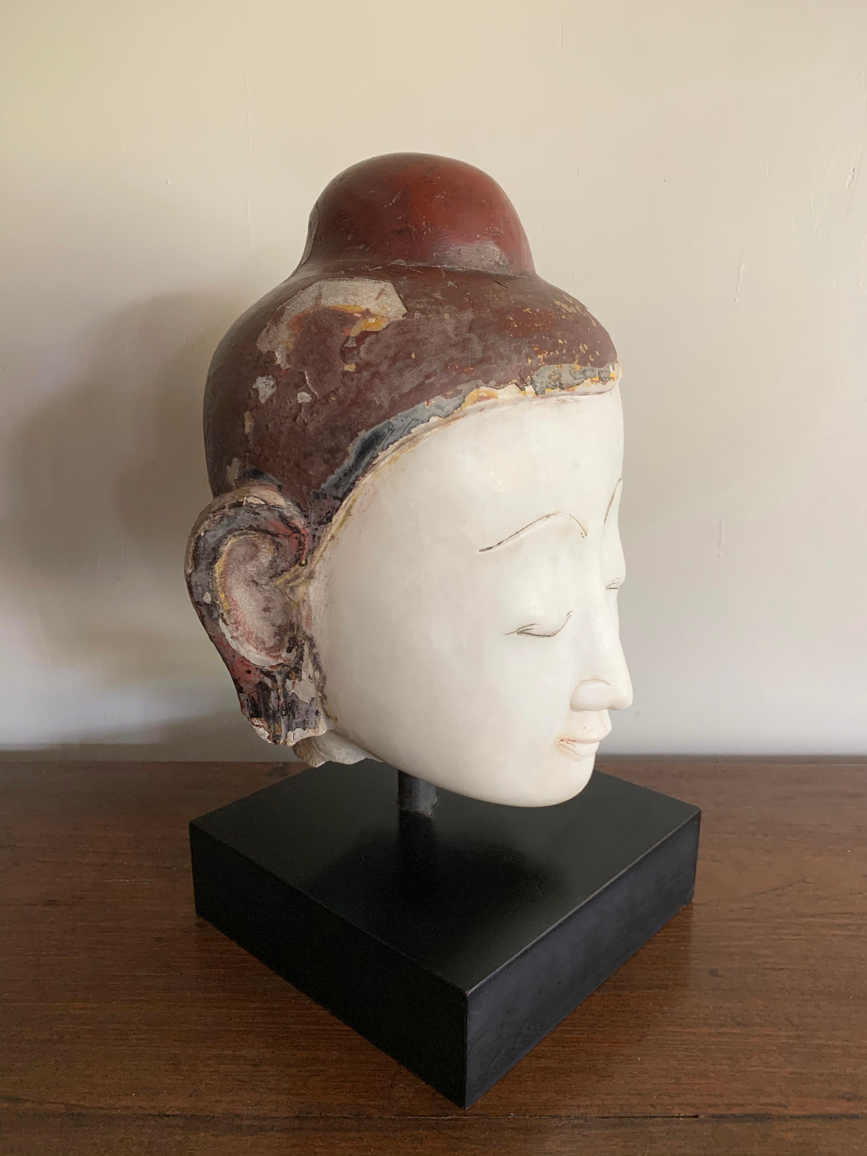 This stunning life-sized marble head of the Buddha is from the Shan States of Burma and carved from a single block of white marble. The Buddha's round, moon like face features arched brows, a pointed nose and closed eyes. The face is framed by
