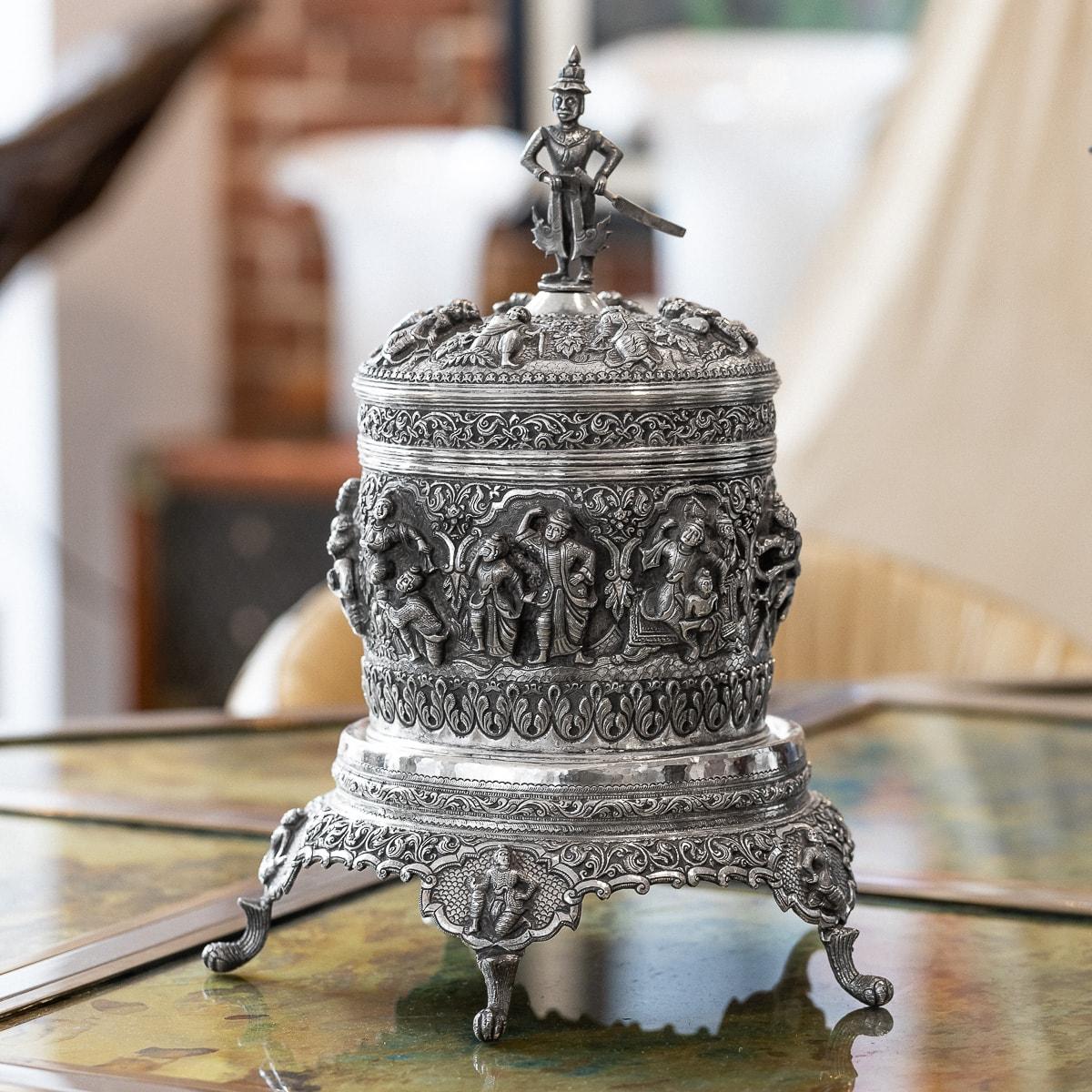 Antique late-19th Century Burmese (Myanmar) solid silver betel box on stand, of traditional shape, highly-decorative, each part is chased in very high-relief with various scenes from Burmese folklore and Buddhism in shaped reserves, surrounded by