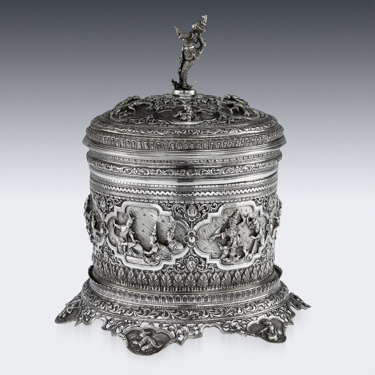 Antique late 19th century Burmese (Myanmar) solid silver betel box on stand, of traditional shape, highly-decorative, each part is chased in very high-relief with various scenes from Burmese folklore, surrounded by scrolling foliage, resting on a