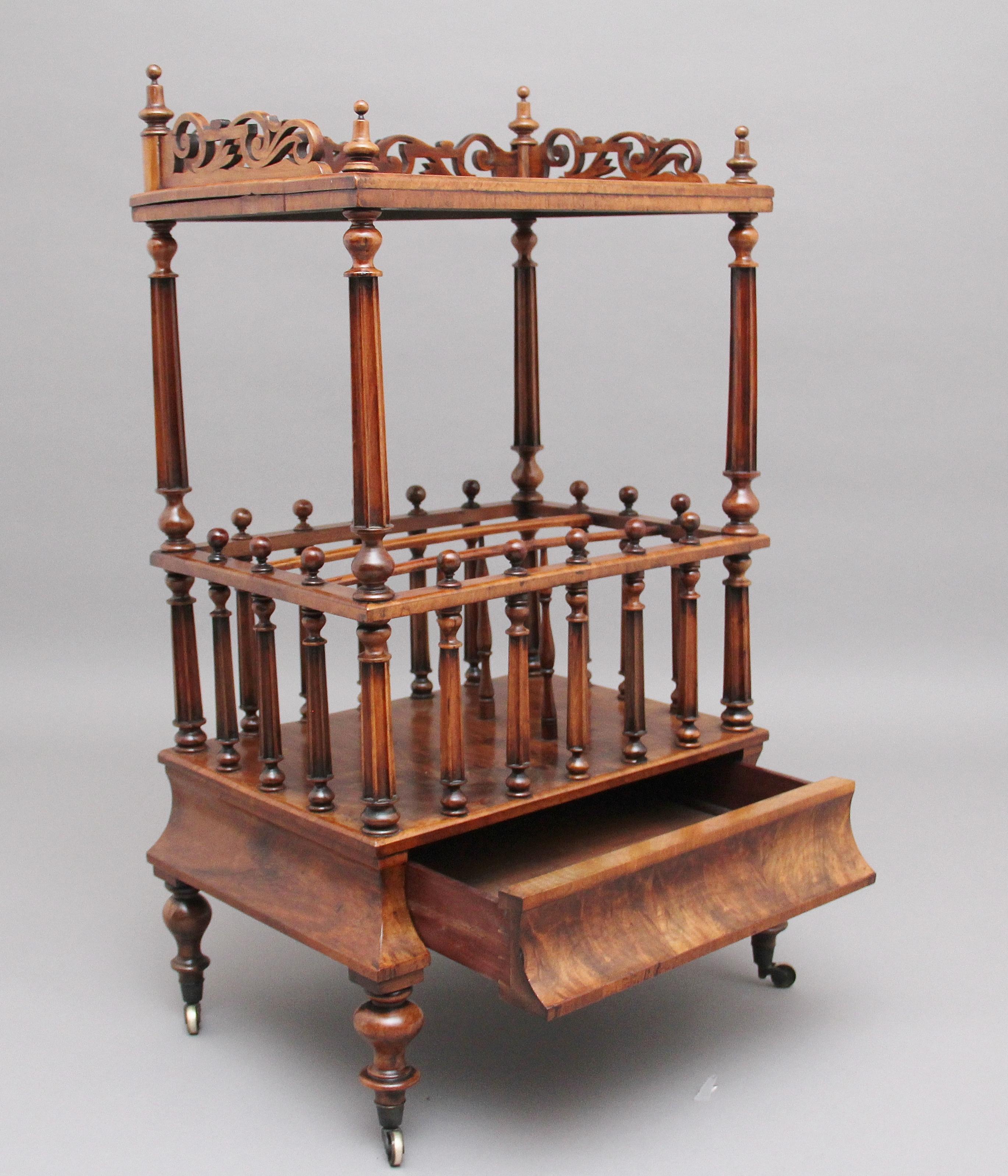19th century burr walnut Canterbury, the burr walnut top having a pierced and carved gallery decorated with turned finials, supported on finely turned fluted columns, the middle section having three divisions surrounded by finely turned fluted