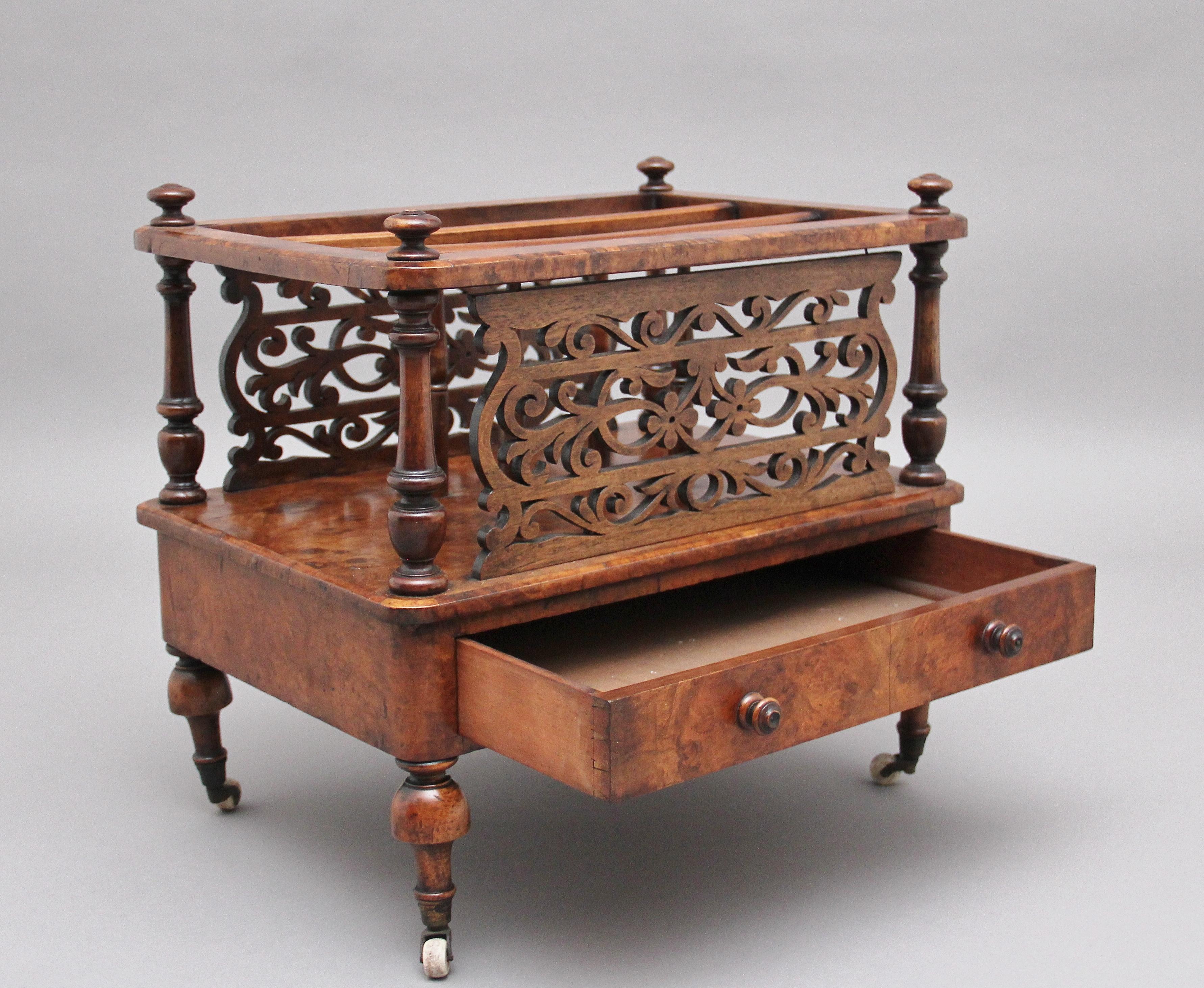 19th century burr walnut Canterbury, having three divisions which is divided by finely carved and pierced splats and turned columns, decorated with turned finials on the top in each corner, having a single mahogany lined drawer at the front with