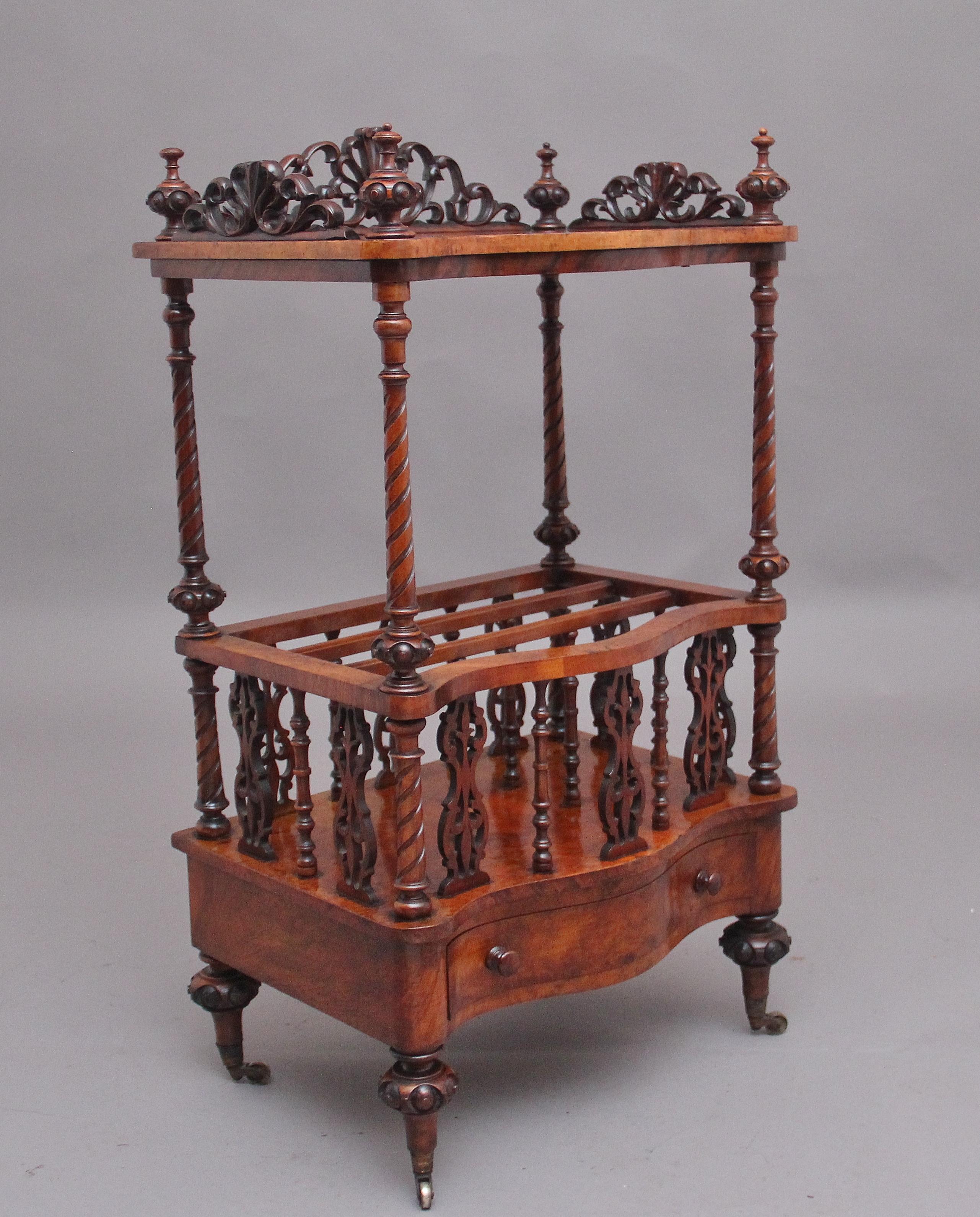 19th Century burr walnut Canterbury of serpentine form, the top having a highly decorative pierced and carved gallery with carved finials in each corner, supported on spiral carved turned columns, the middle section having three divisions which is