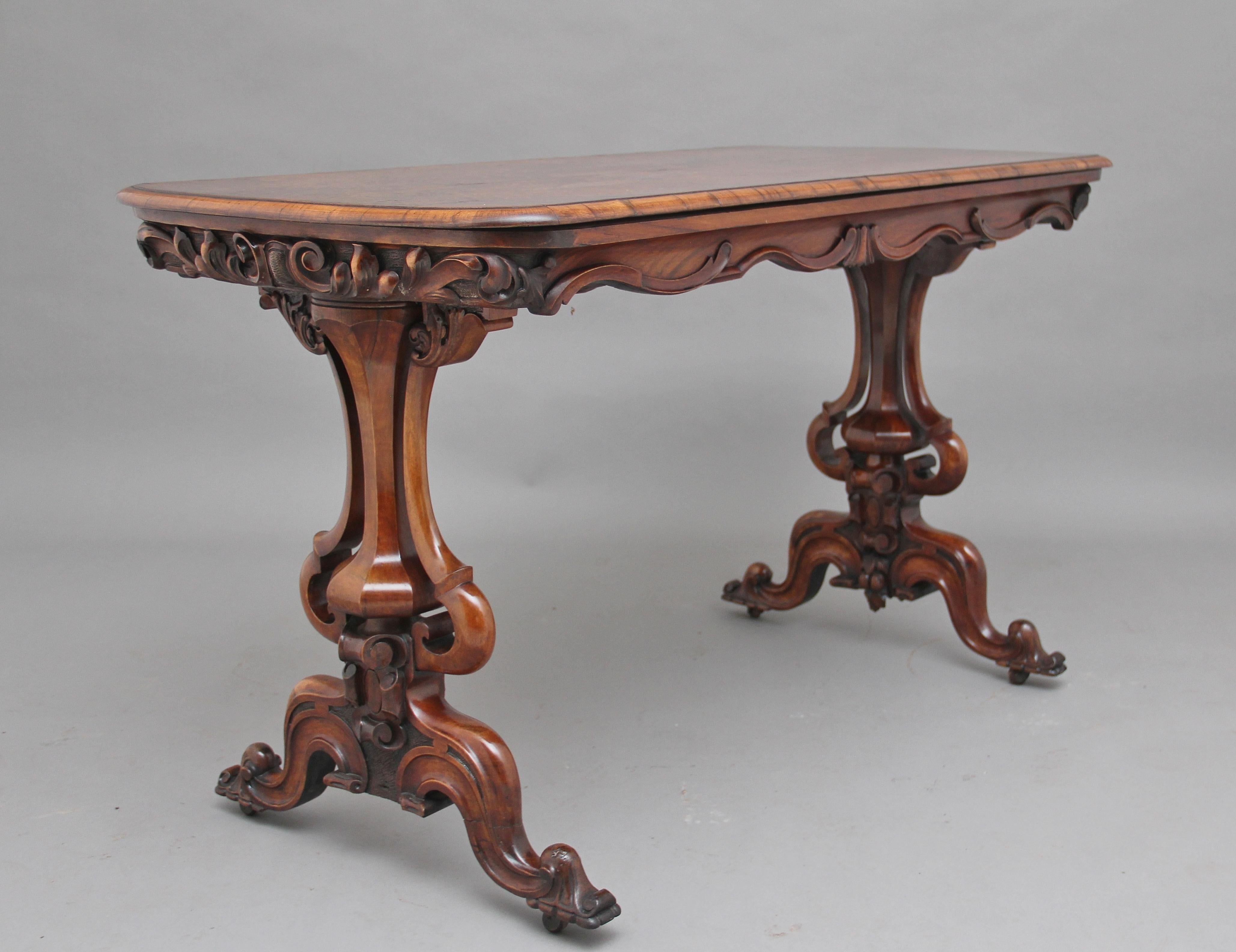 19th century burr walnut centre / stretcher table, having a quarter veneered top with a moulded edge, the shaped and carved frieze below with the sides having lovely carved floral decoration, supported on wonderfully carved and shaped end supports