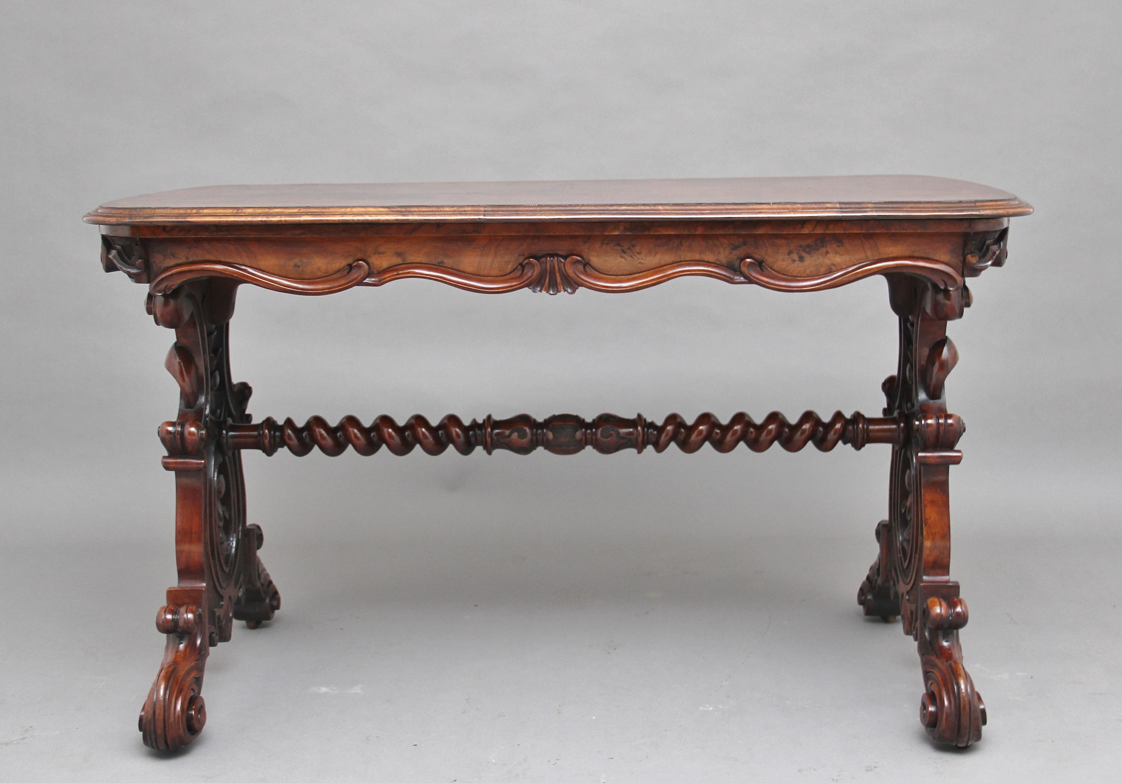 A superb quality 19th century burr walnut centre / stretcher table, having a quarter veneered top with a double moulded edge, the shaped and carved frieze below having lovely bold carving along all sides, supported on lyre end supports with