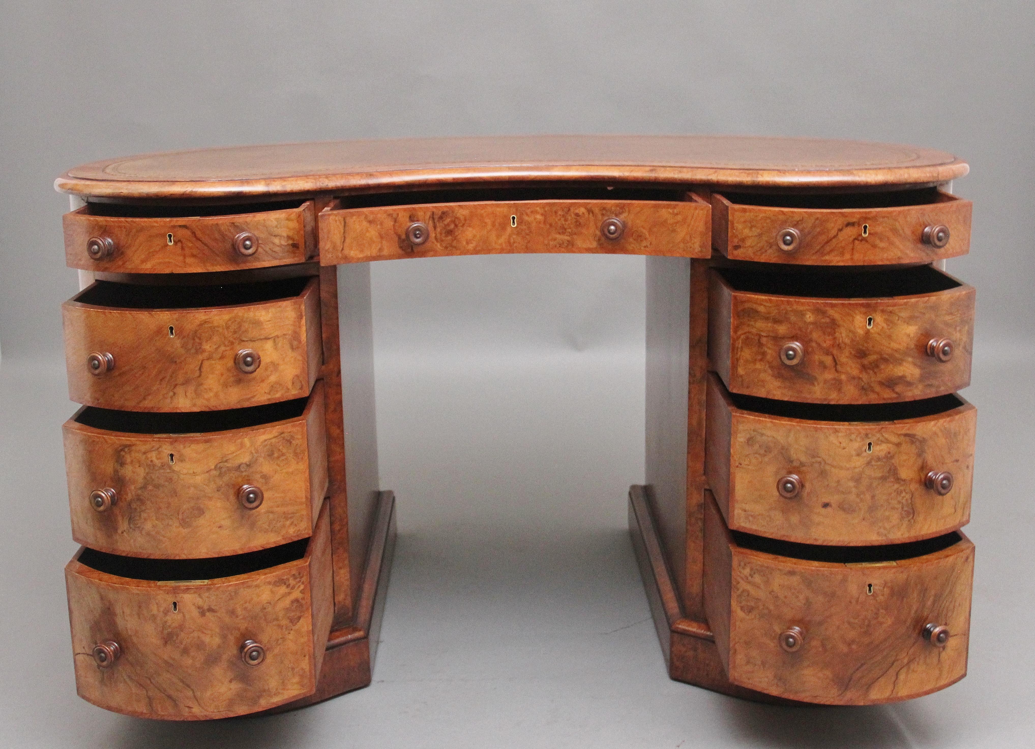 A freestanding 19th Century burr walnut pedestal kidney shaped desk of exceptional quality, the moulded edge top having a tan brown leather writing surface decorated with gilt tooling, the front of the desk having an arrangement of nine graduated,