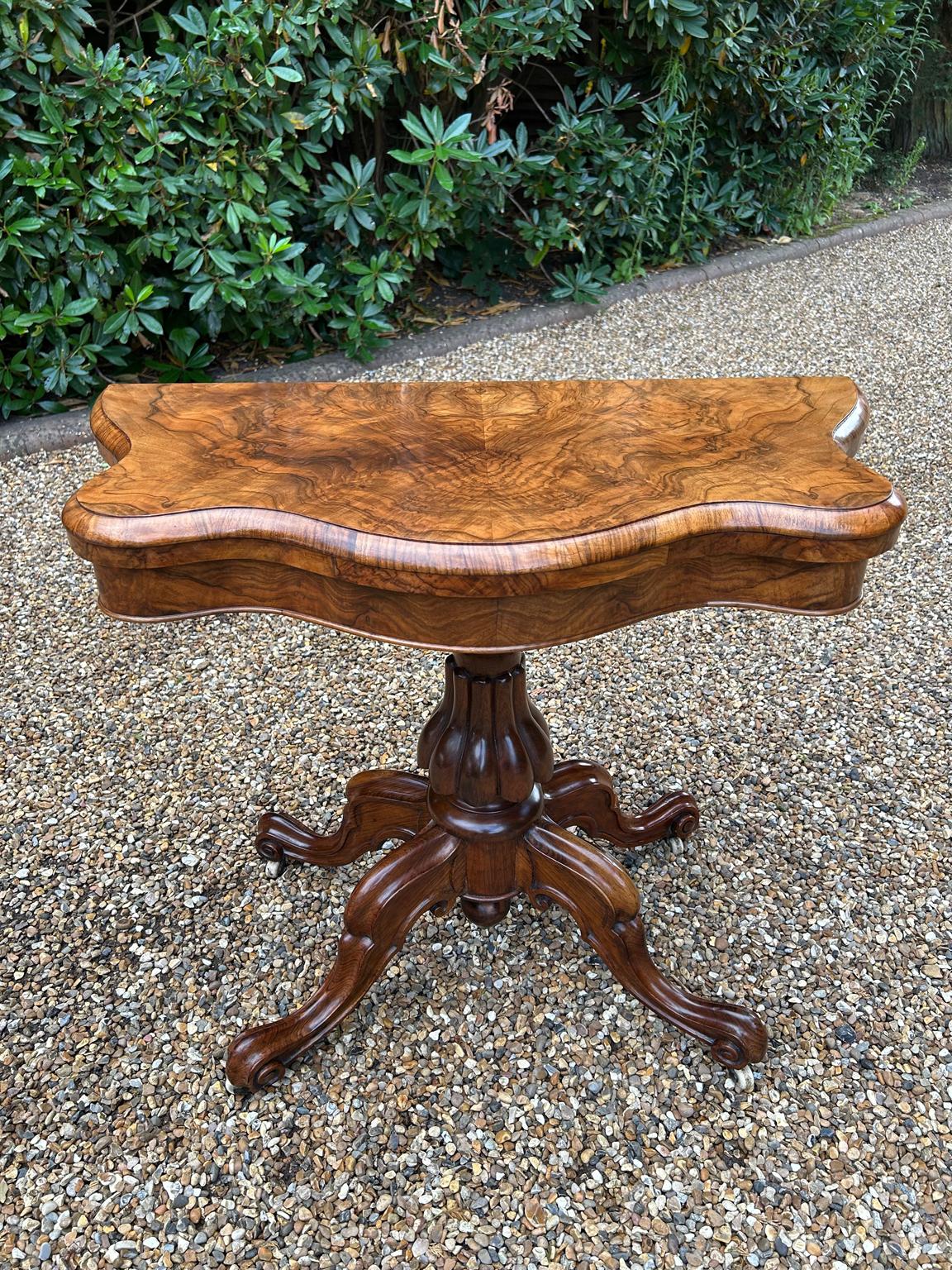 A very high quality 19th Century Victorian Burr Walnut Serpentine Card Table of exceptional quality and condition. With turned and carved column supports, four well carved and shaped cabriole legs with original castors. The top rotates by 90 degrees
