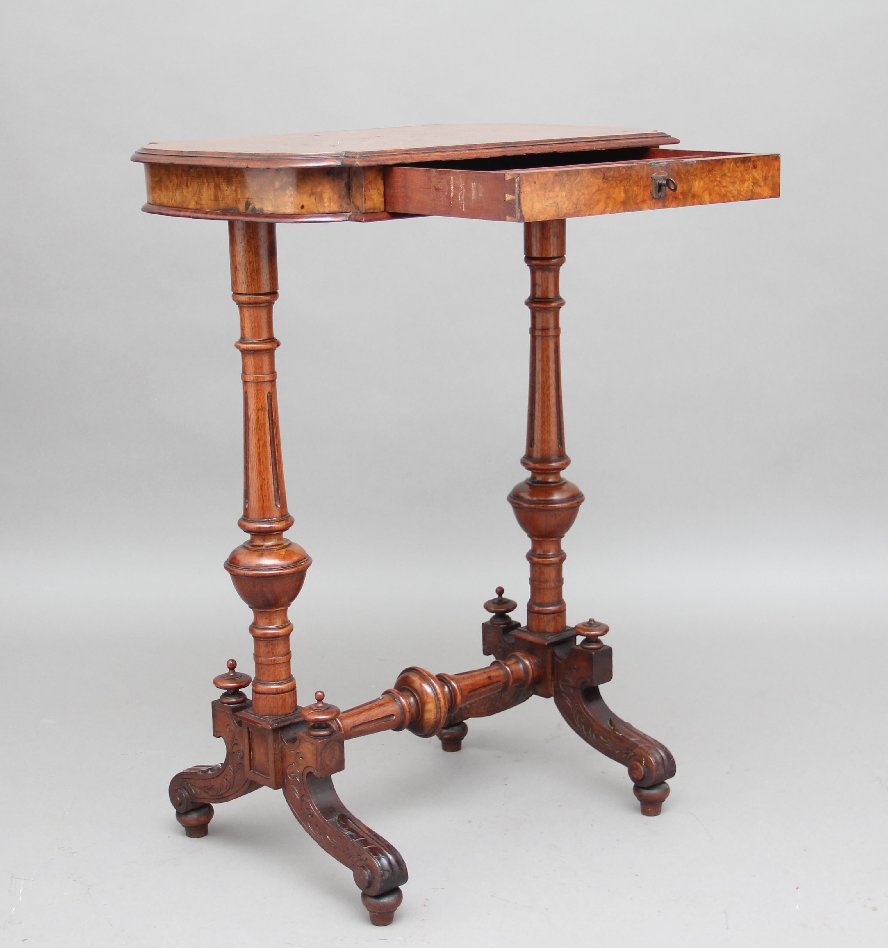 19th century burr walnut side / occasional table, the shaped top is crossbanded with a molded edge, the frieze having a single drawer, supported by a pair of turned columns and shaped and carved feet with finials and united by a turned stretcher,