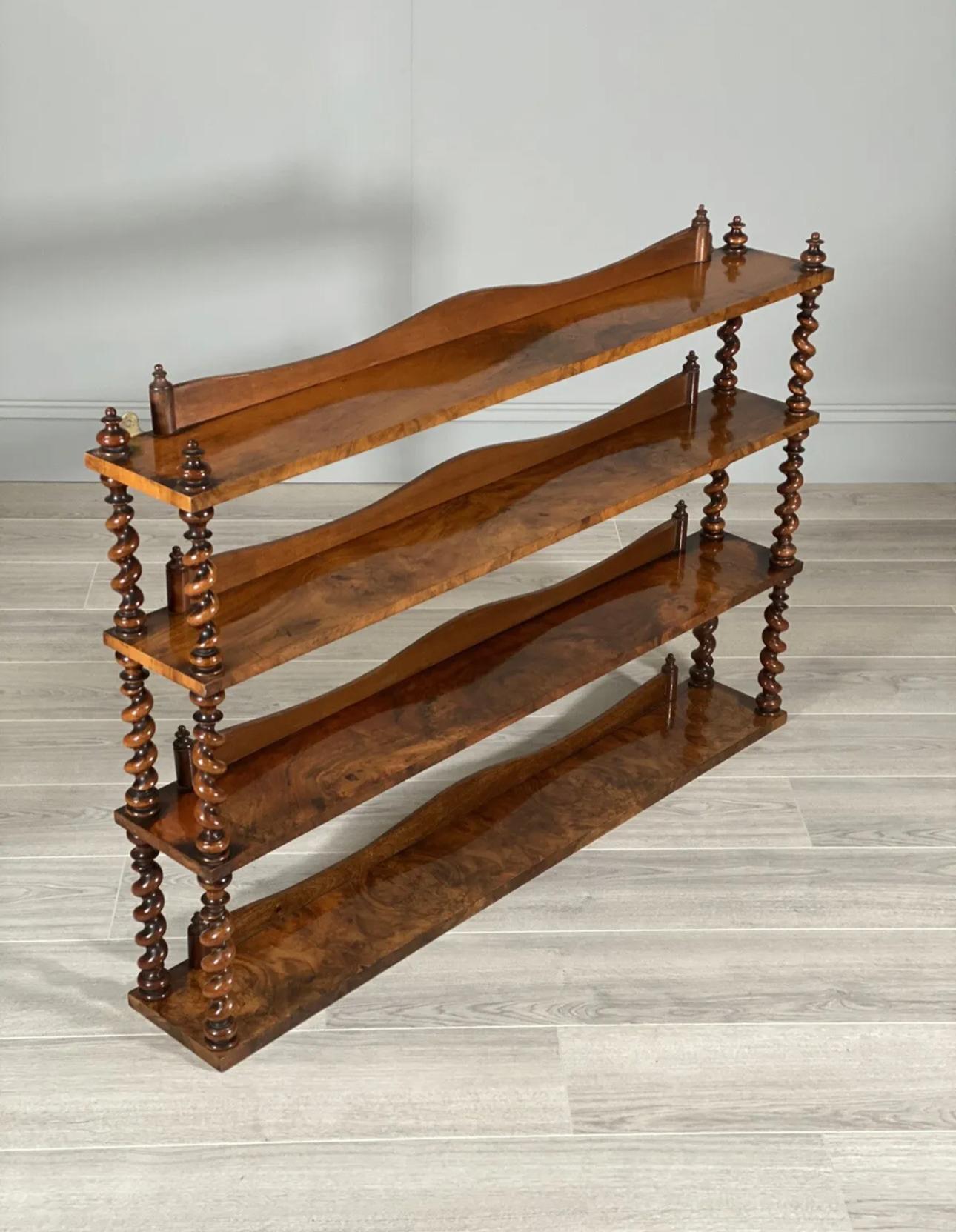 Burr walnut wall hanging shelves dating to the late 19th century. The unit consists of four shelves each with a back panel, twisted columns to the front and back and original brass hanging points. A stunning example with a wonderful rich colour.