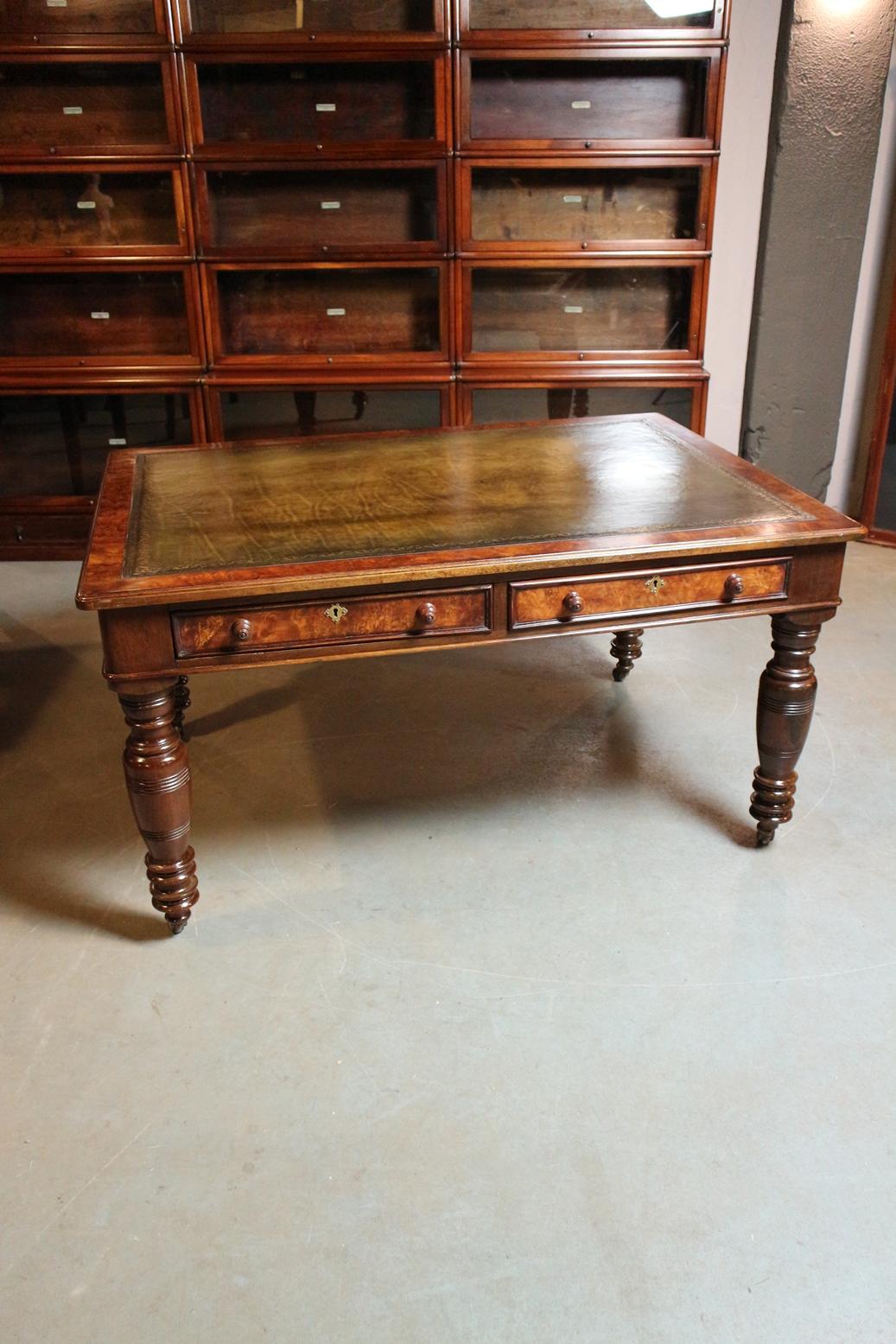Beautiful antique burr walnut combined with mahogany writing table. The table has 2 drawers on both sides. Table stands on porcelain wheels. Green gold-tooled leather top. Nice warm color.
Origin: England, ca. 1840 In good and complete original