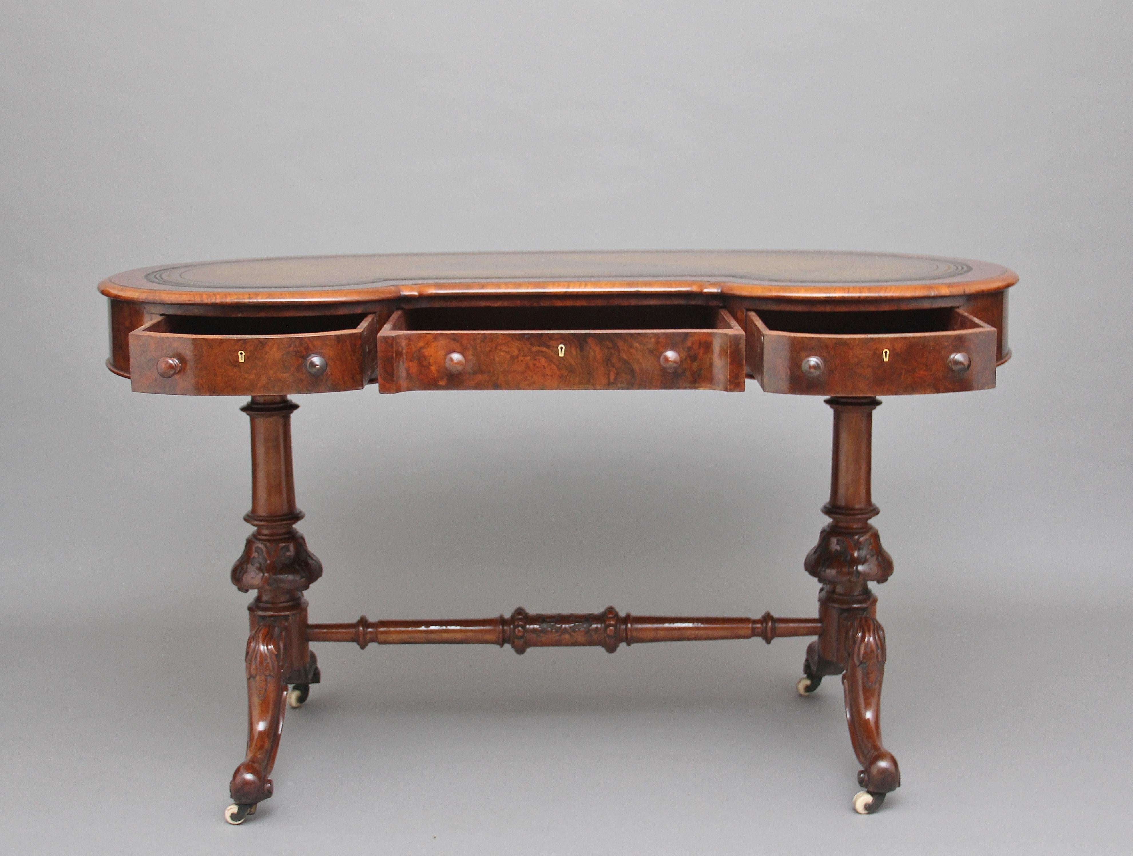 A good quality 19th century burr walnut writing table, the molded edge kidney shaped top, having a tobacco colored leather writing surface decorated with blind and gold tooling, the frieze below having three mahogany lined drawers with original