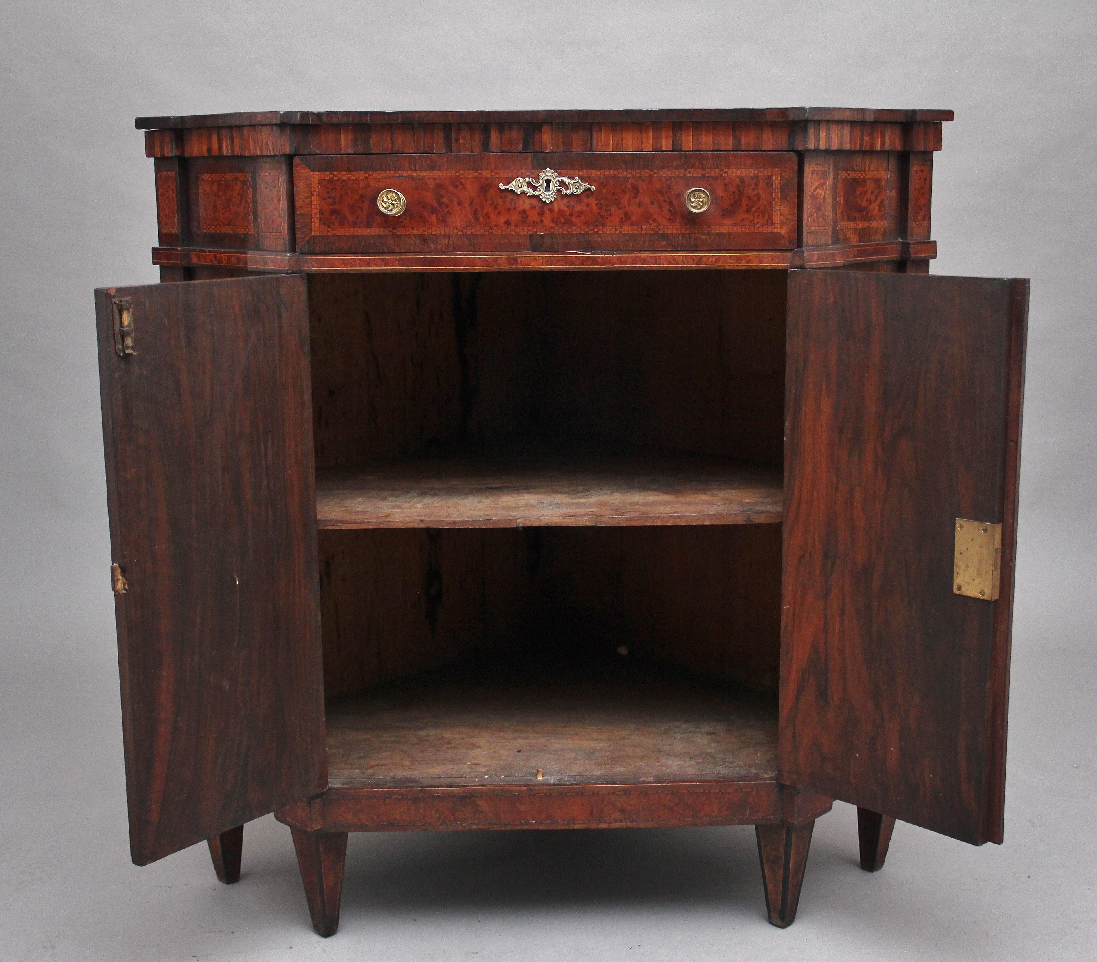 A highly decorative 19th century burr yew wood and inlaid corner cabinet by “Druce & Co” of London, the shaped top crossbanded and having decorative boxwood and chequered inlay with an oval shell inlay at the centre, having an oak lined frieze