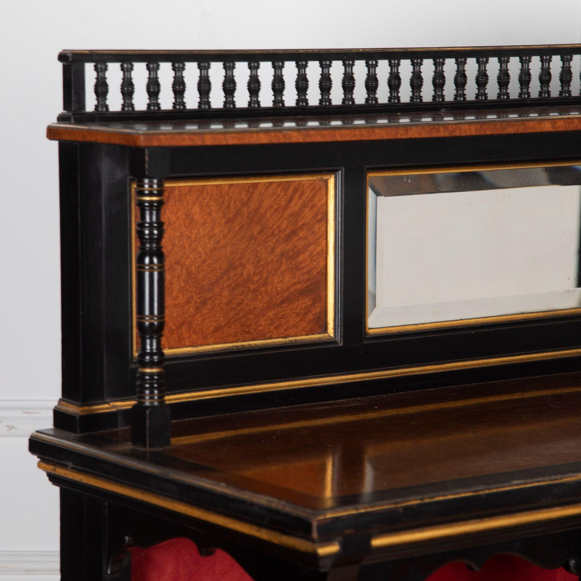 Fine quality late 19th Century Arts and Crafts ebonised and amboyna cabinet by Marsh Jones and Cribb.
The superstructure with a central mirror flanked by timber panels with a galleried shelf above. The base has a quarter-panelled door with a