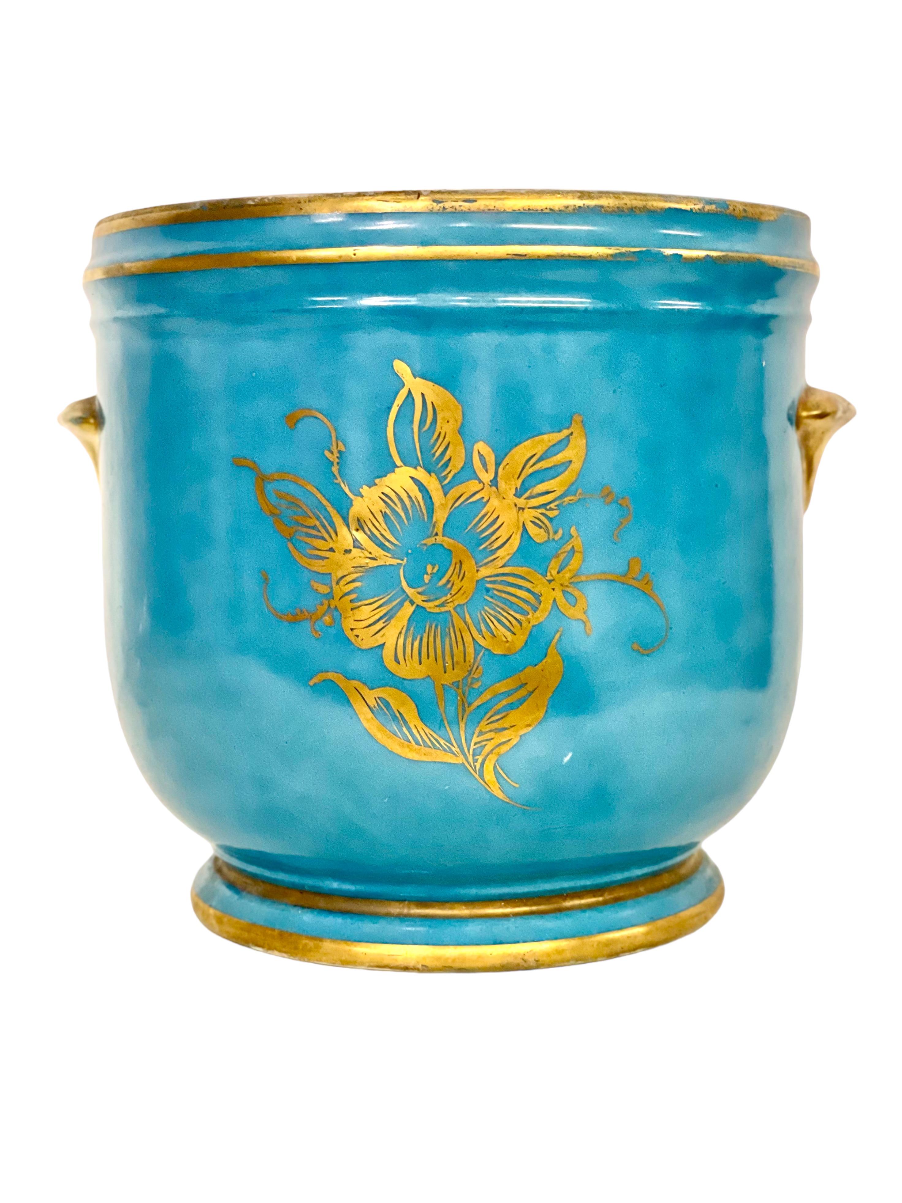 A beautiful and vividly coloured 19th century cache pot, or jardinière, lovingly crafted from Limoges porcelain in the 18th century Sèvres style. This charming planter features two side handles, and is glazed in classic powder blue, highlighted
