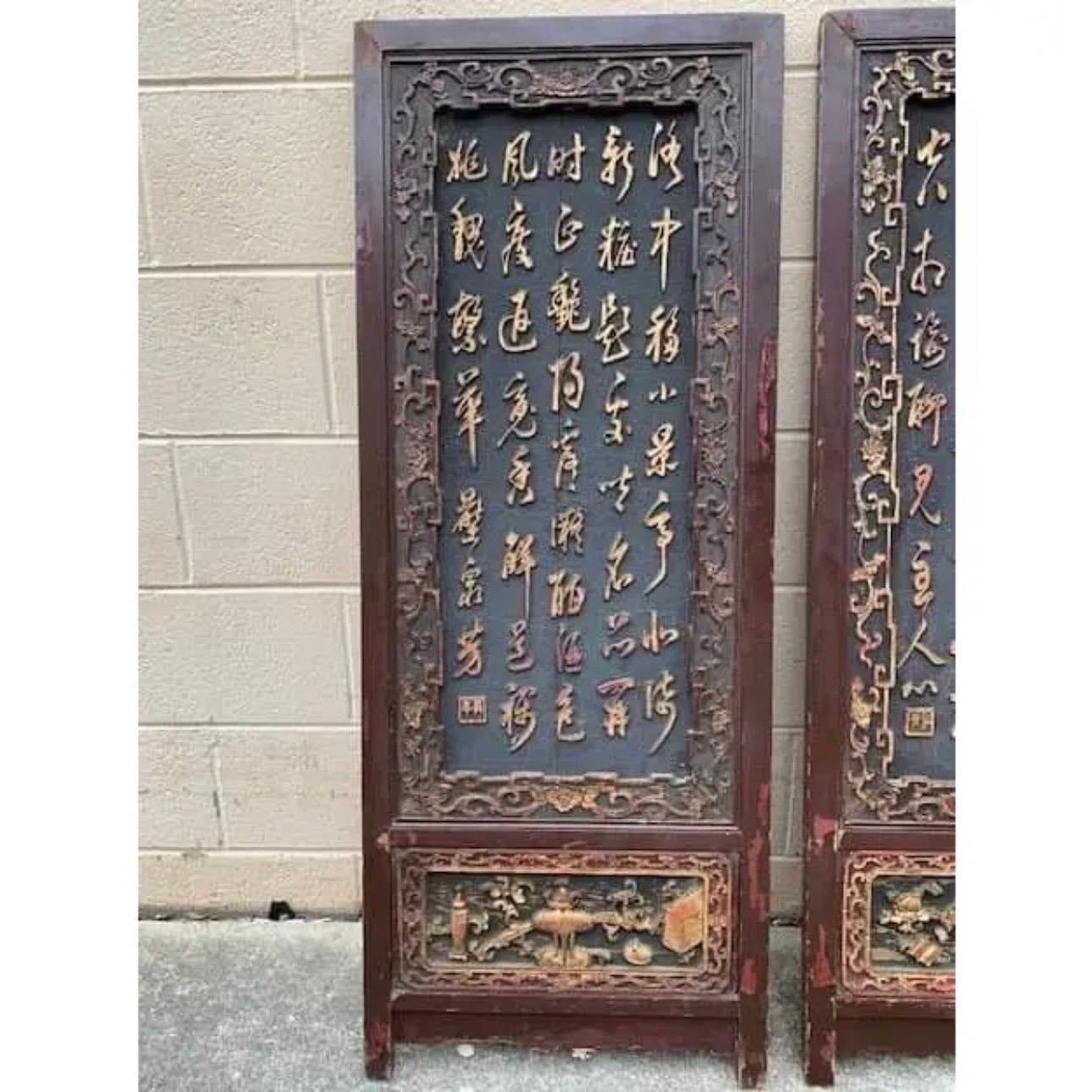 A pair of wooden Chinese Calligraphy panels dating from the early 19th Century. Gold calligraphy is set in ornately carved frames.