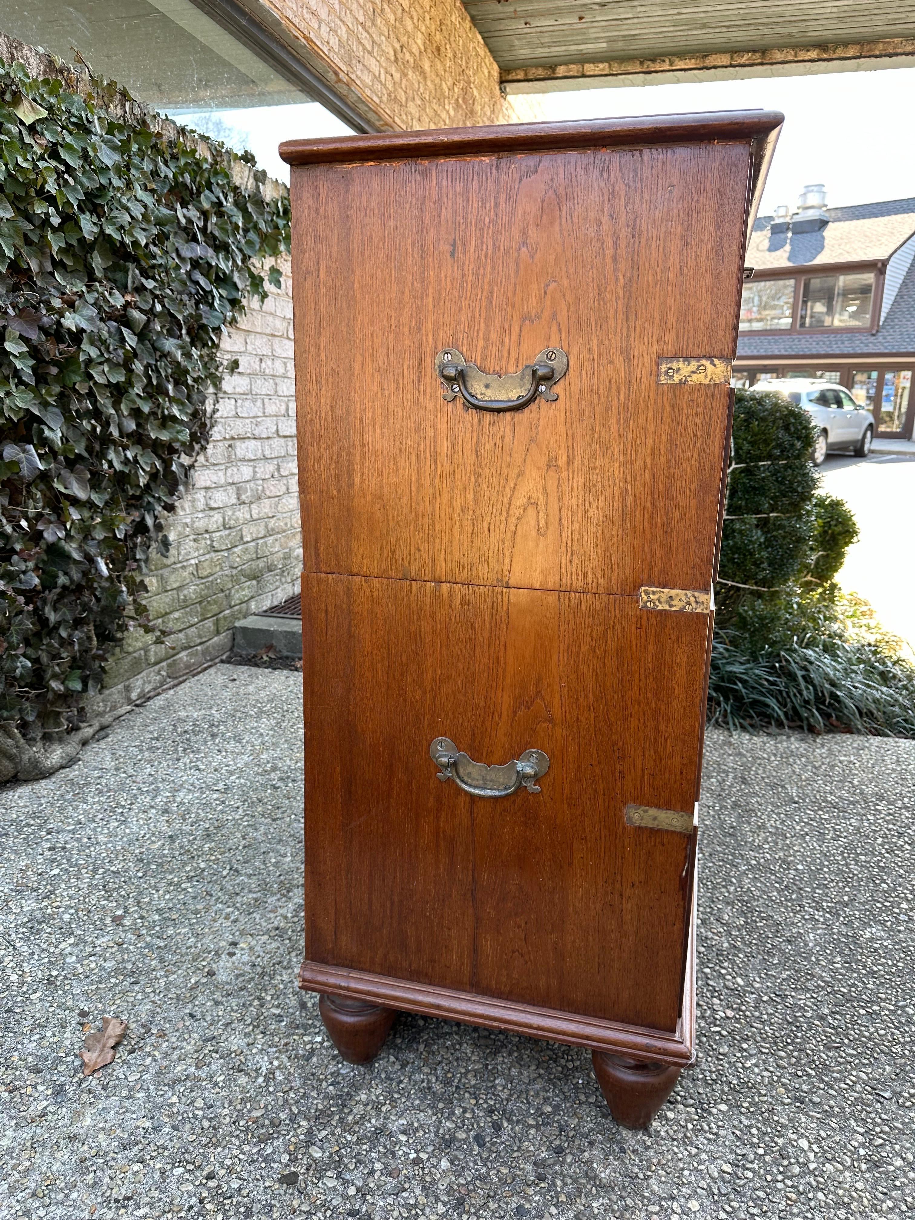 Tall campaign chest with brass hardware and fittings.... two-pieces stacked, the lower with feet.....