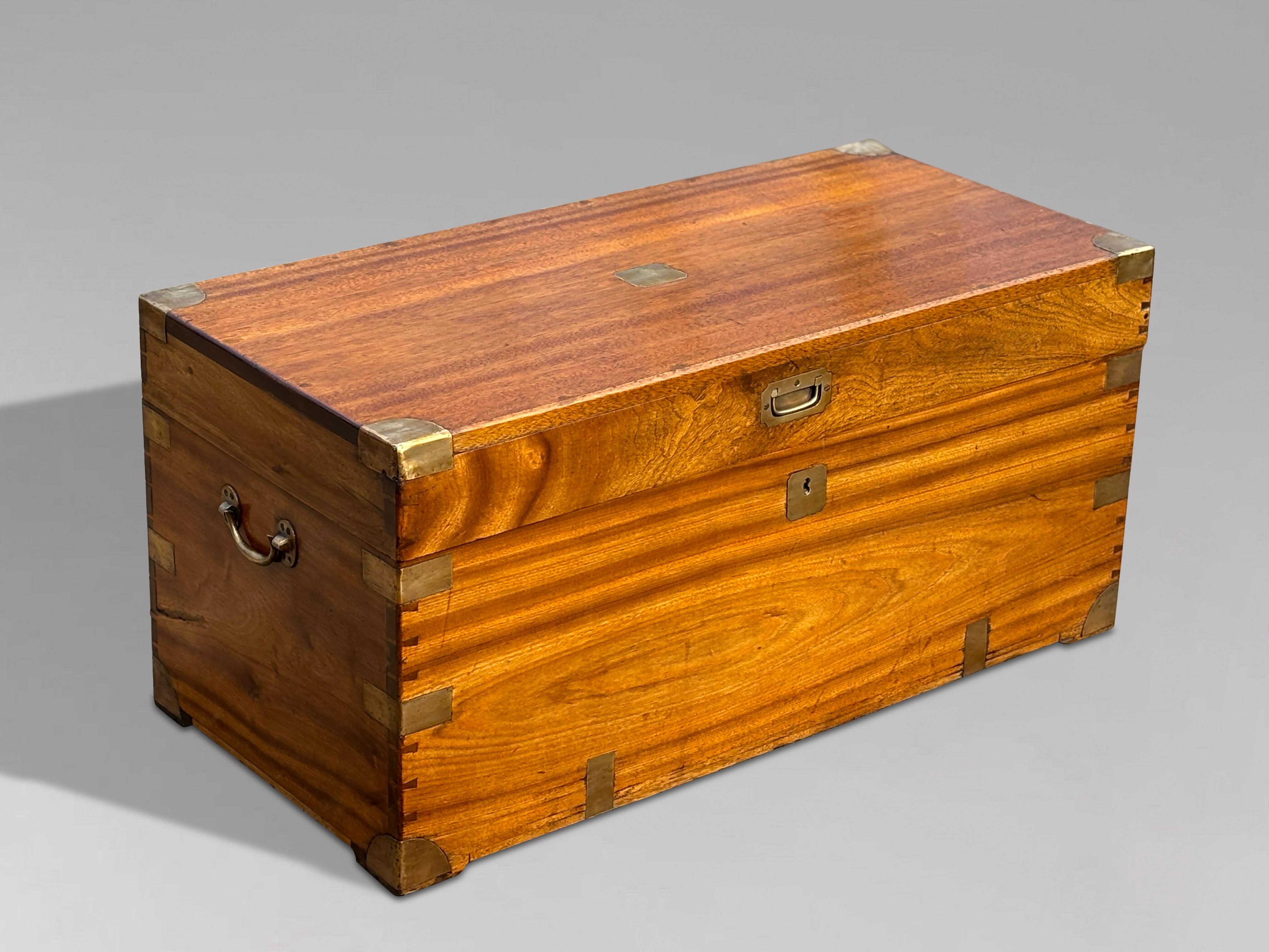 A large late 19th-century camphor wood brass-bound travelling campaign trunk with brass mounts and brass carrying handles. It features a warm, rich colour and patina, suitable for use as a decorative coffee table. The early timbers exhibit a deep