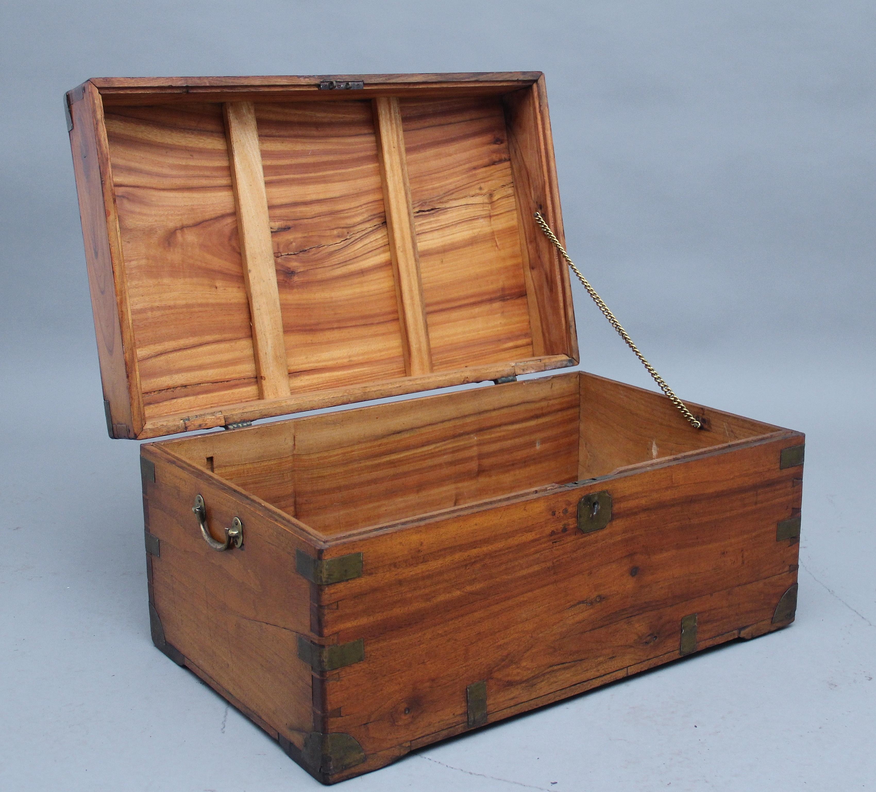 19th century camphor wood trunk with brass straps and corners, the hinged lid opening to reveal a large compartment space, the sides of the trunk having the original brass carrying handles. In fantastic condition and ideal for use as a coffee table,