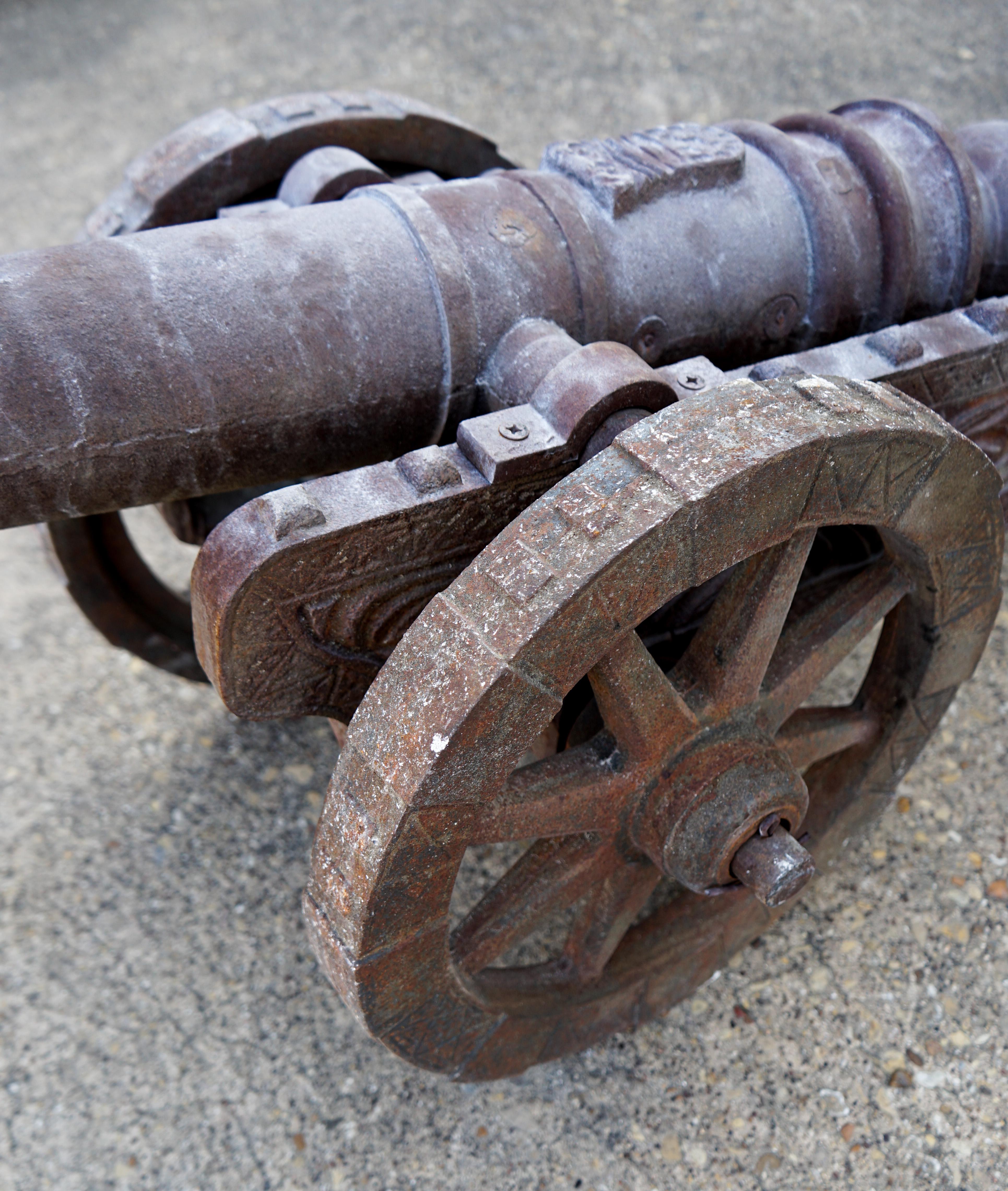 This decorative iron canon was forged in the early 19th century. It has a number of subtle details such as a family crest on barrel of the canon. A bold statement for any garden or gun room.

Measurements: 57'' L x 23'' W x 19'' H.