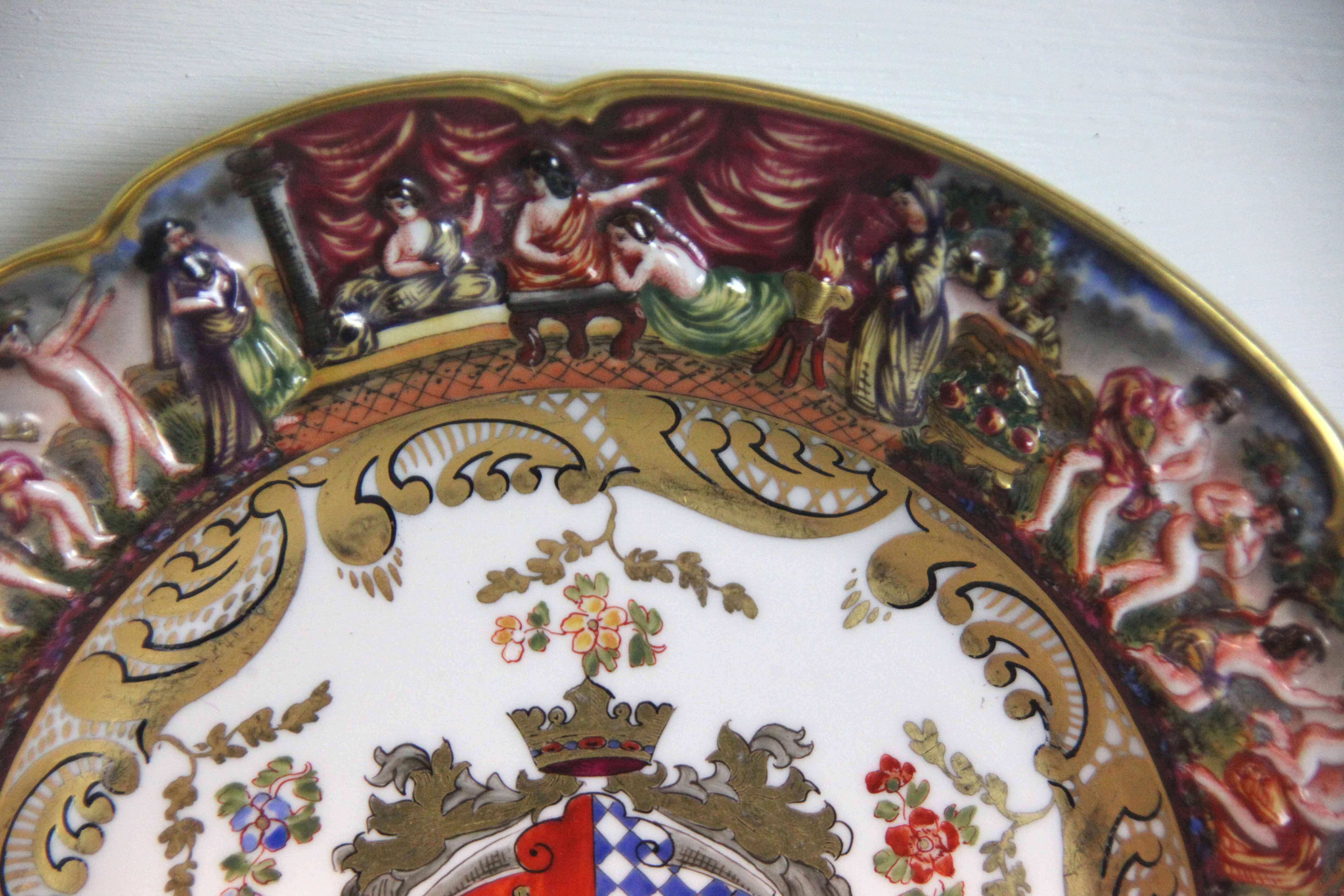 19th century Capodimonte plate, with shaped rim, the border with classical scenes, center featuring coat of arms.