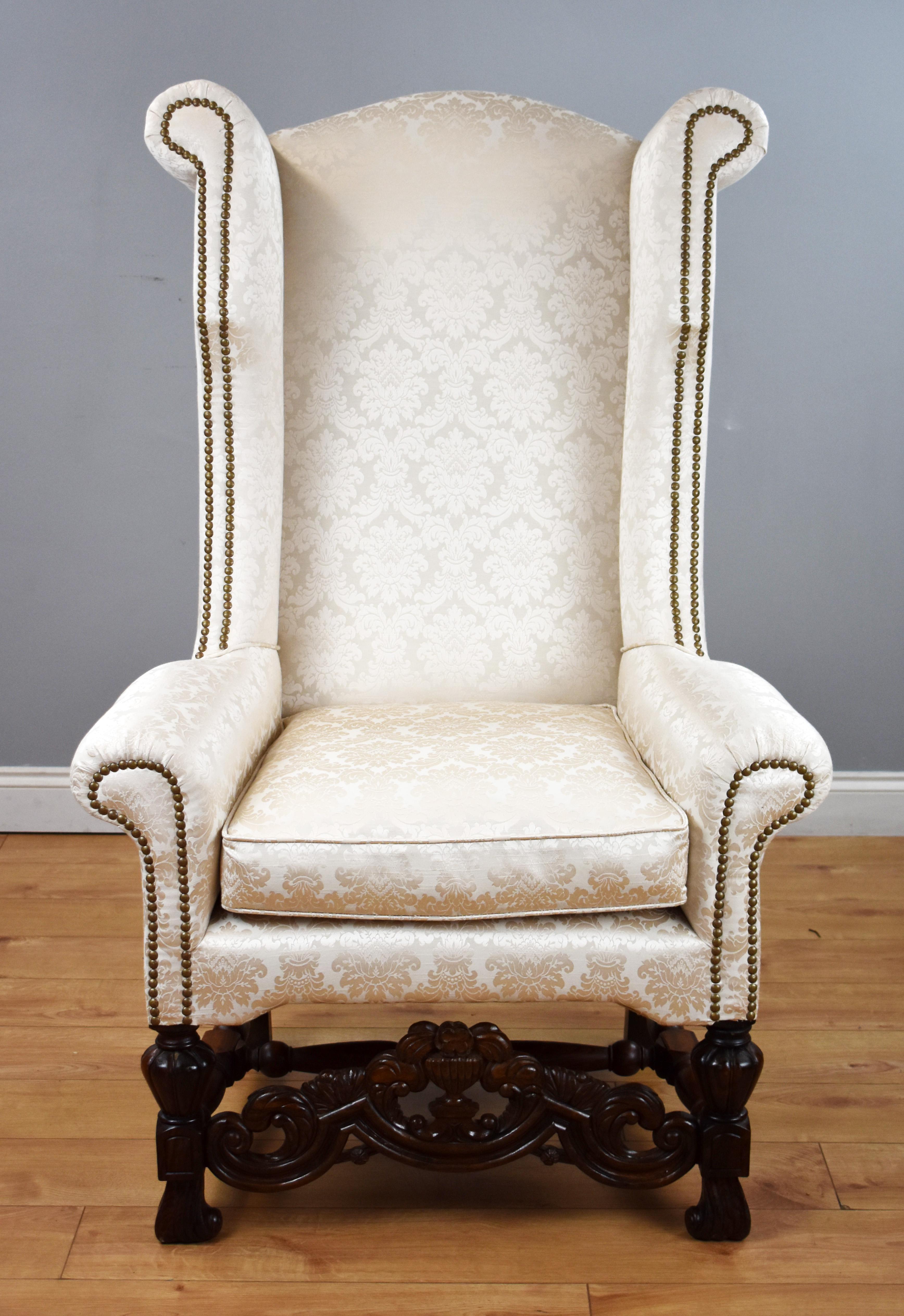 Zum Verkauf steht ein hochwertiger Ohrensessel im karolingischen Stil des 19. Jahrhunderts mit einer hohen Rückenlehne über einem Sitzkissen und einer kunstvoll geschnitzten Bahre, die die gedrechselten Beine verbindet. Der Stuhl ist in einem sehr
