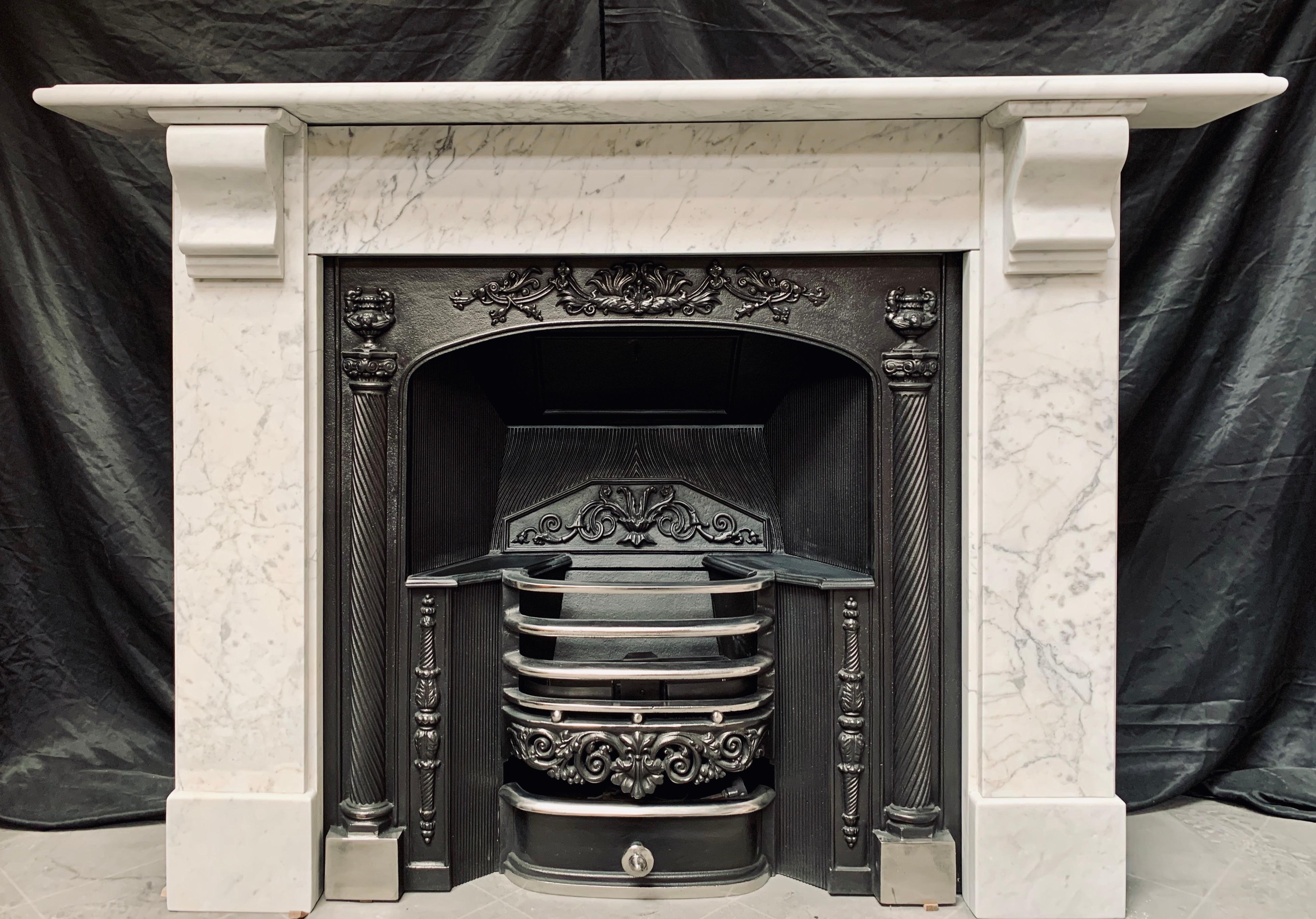A simple 19th century Carrara marble corbelled fireplace surround, a scalloped shelf sits above an unadorned frieze, flanked by stepped jambs hosting large corbels and capping, all resting on a plain foot block.

English, circa 1890
Fire opening
