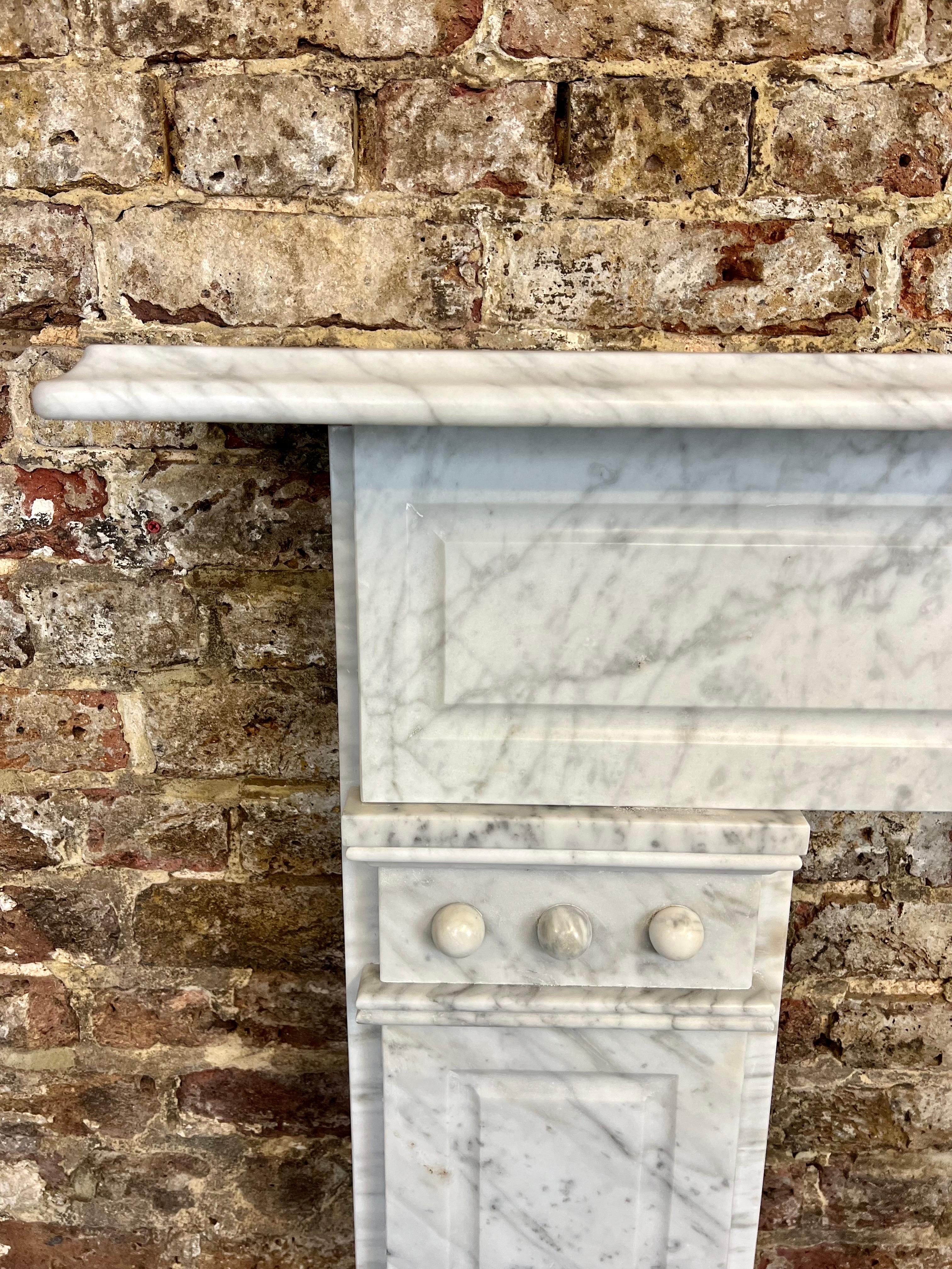 A delightful 19th century Victorian white Carrara honed marble fireplace mantelpiece. 
This fireplace surround has been recently salvaged and restored from a London city town house. 
This antique marble fireplace has recessed leg panels and a