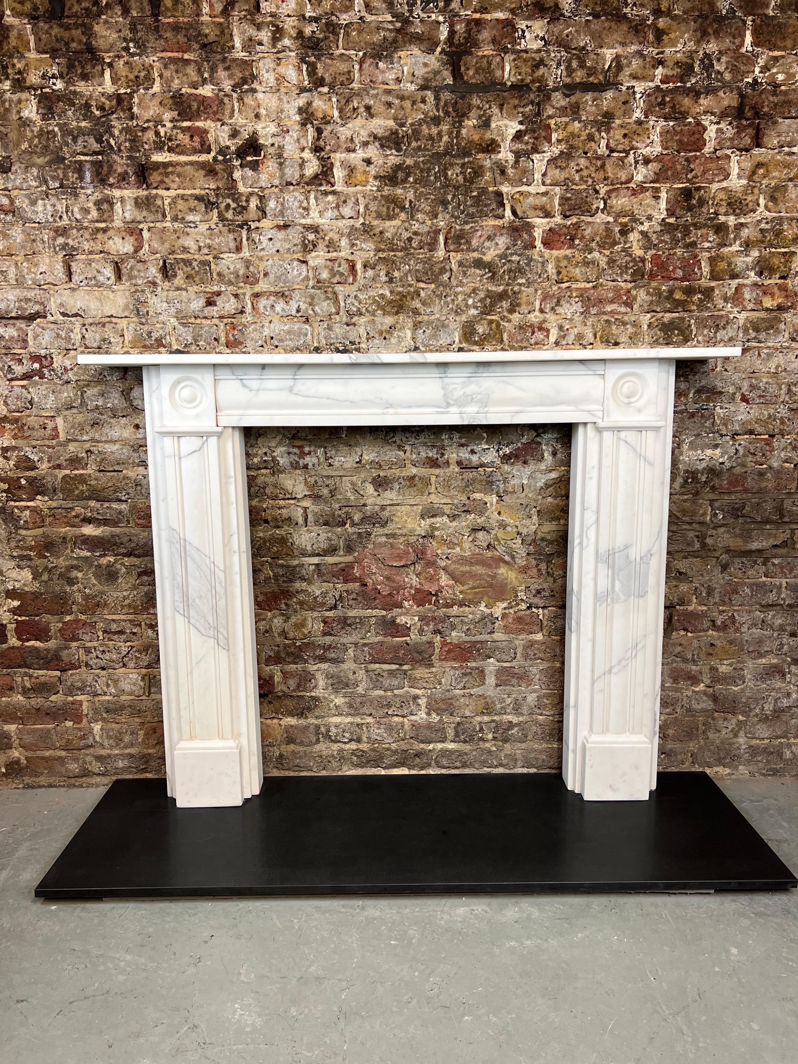 19th Century Carrara Marble Fireplace Mantlepiece.
Bullseye Style Fireplace Surround With Demi Recessed Panels Within The Jabs & Centre Frieze. English Made From Italian Light Carrara Marble.
Dated Circa 1860-1880. Recently Salvaged From A London