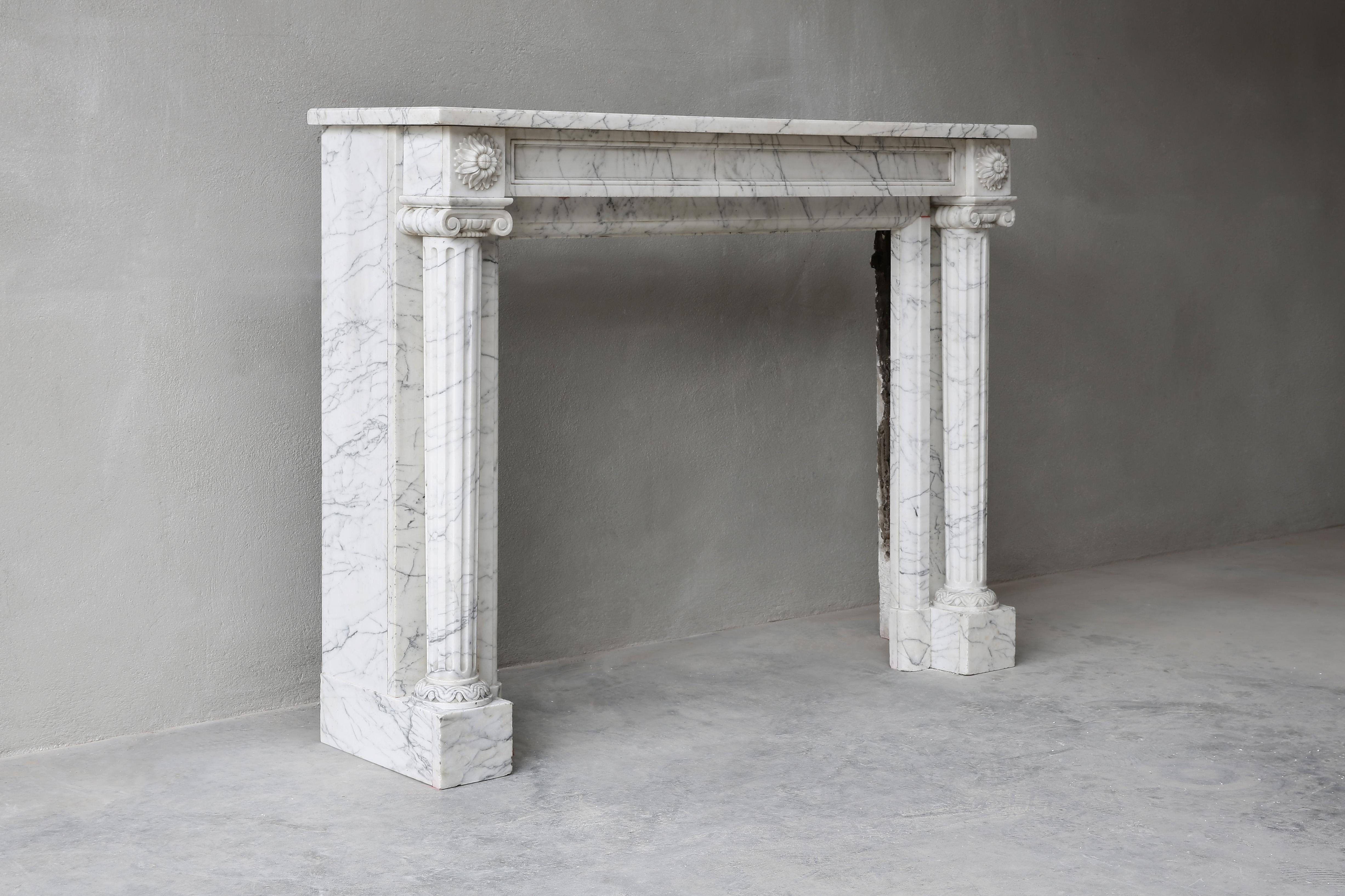 Beautiful antique fireplace in Carrara marble from the 19th century! This fireplace is in Louis XVI style and comes from Paris. The mantelpiece has charming ornaments and decorations and the legs are fluted. A beautiful model fireplace that fits