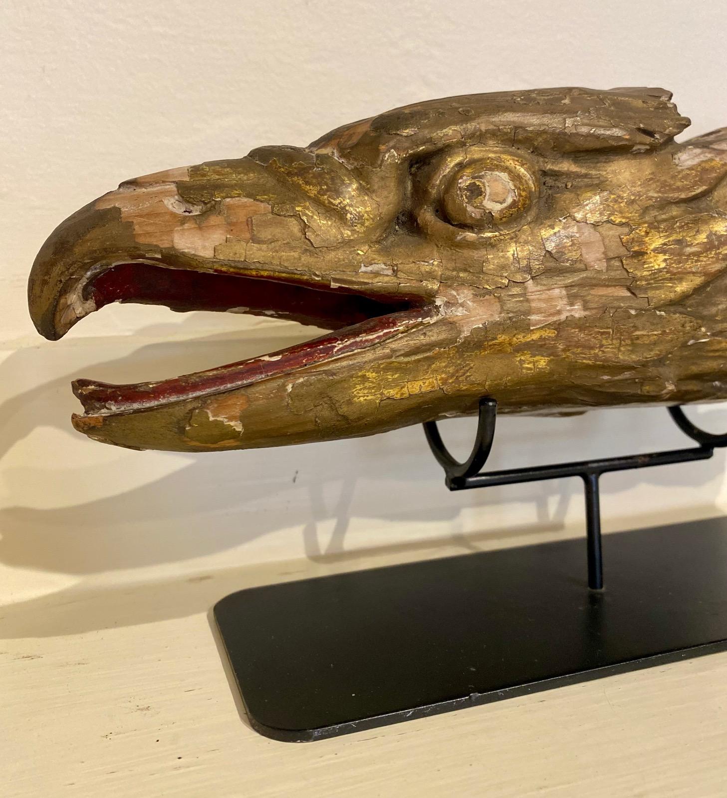 19th century carved and gilded eagle head ship's carving, found on the coast of Maine, a finely carved cedar block with open beak, partially articulated tongue, deeply relief carved eyes, row, and feathers. The reverse has a flat cut surface and an