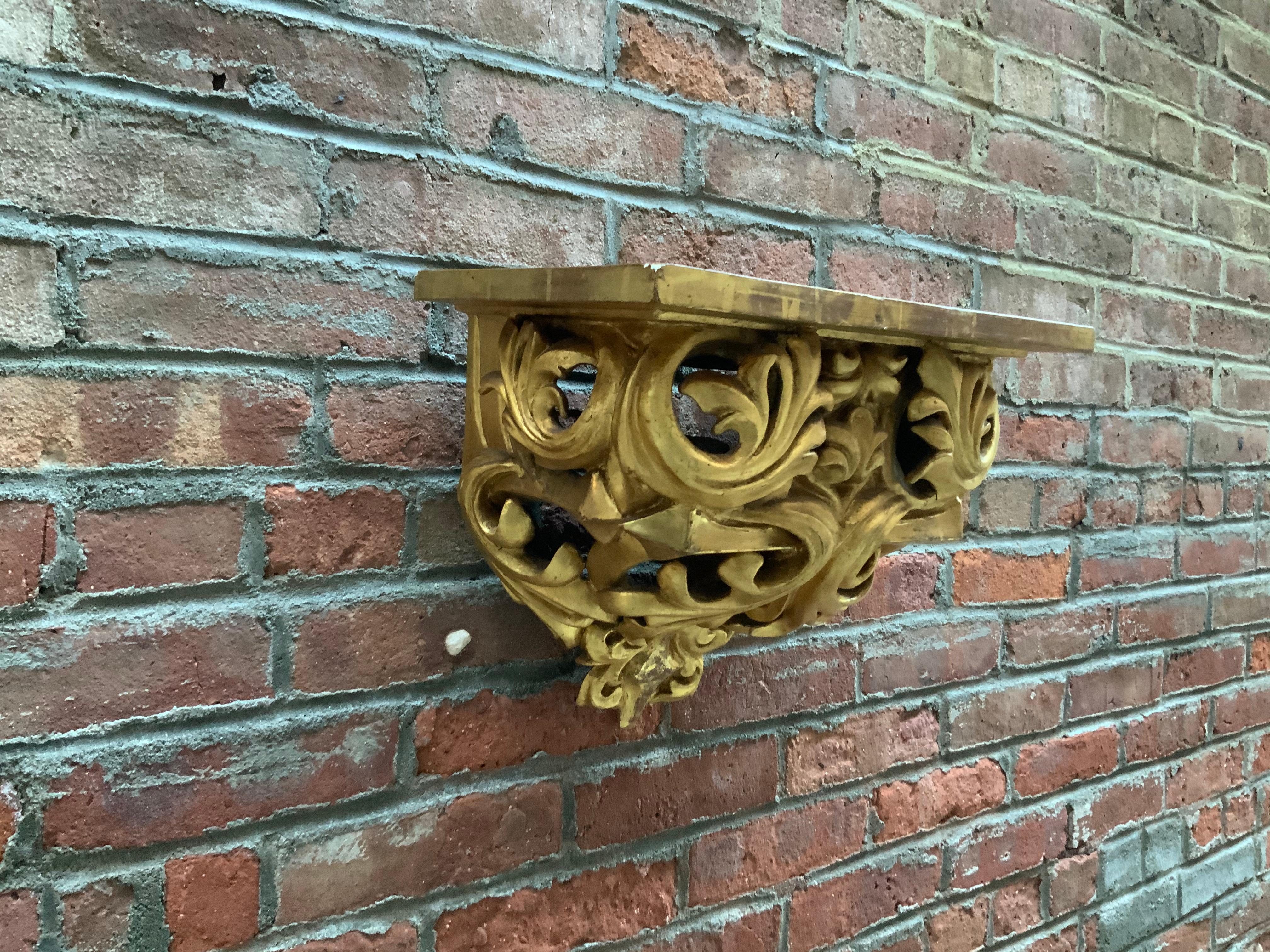 19th century carved and gilded Italian floral and scroll shelf. Water gilded with hints of the original red bole peeking through worn areas. A wonderful accent shelf that can go anywhere. Some light areas of wear and maid's marks. The flat surface