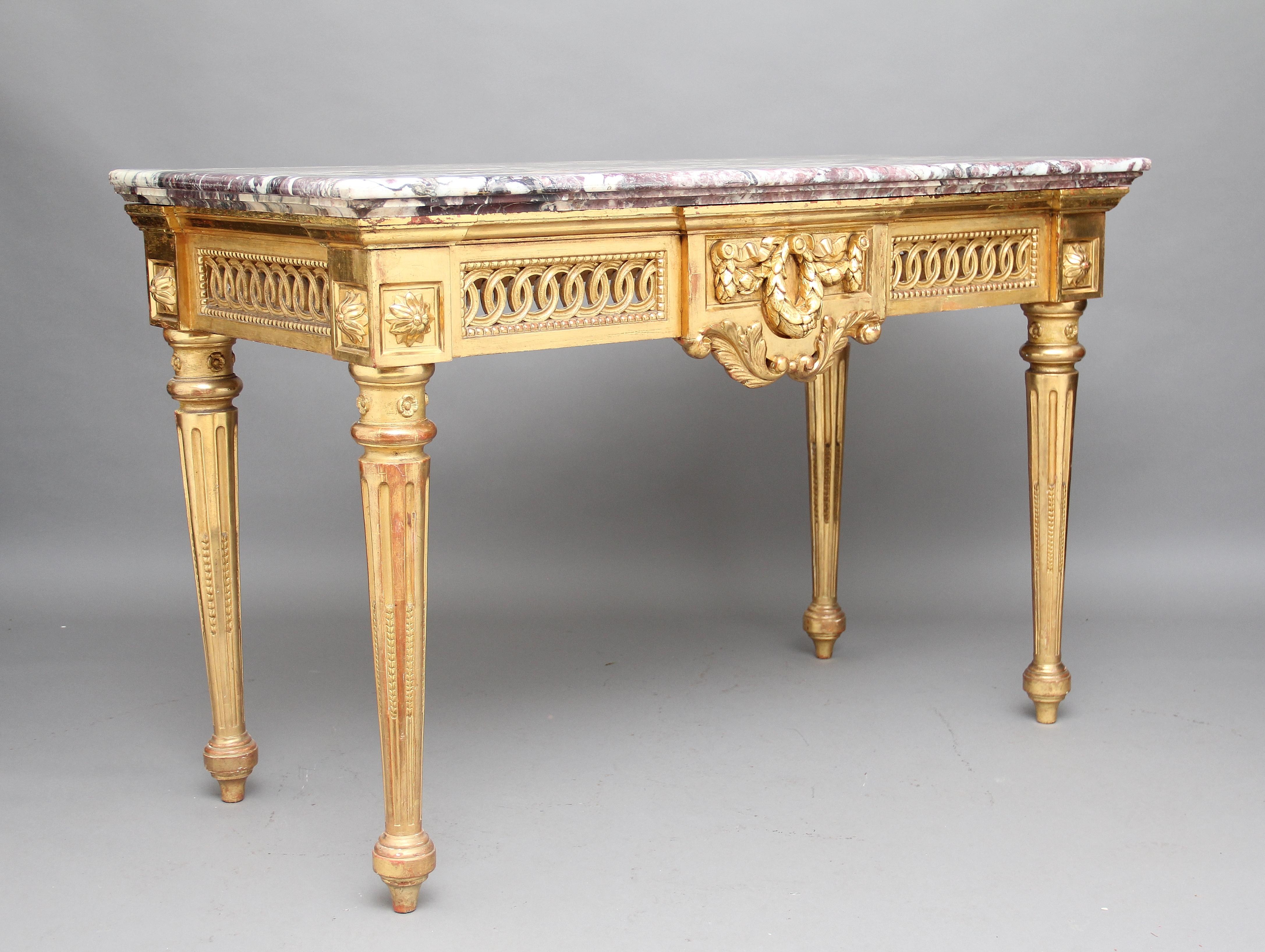 A fabulous 19th century French carved and gilt consultable with a wonderful colored marble top having a lovely molded edge, standing on four turned and fluted legs, at the top of the legs is an inset panel with a carved patrae, there are pierced