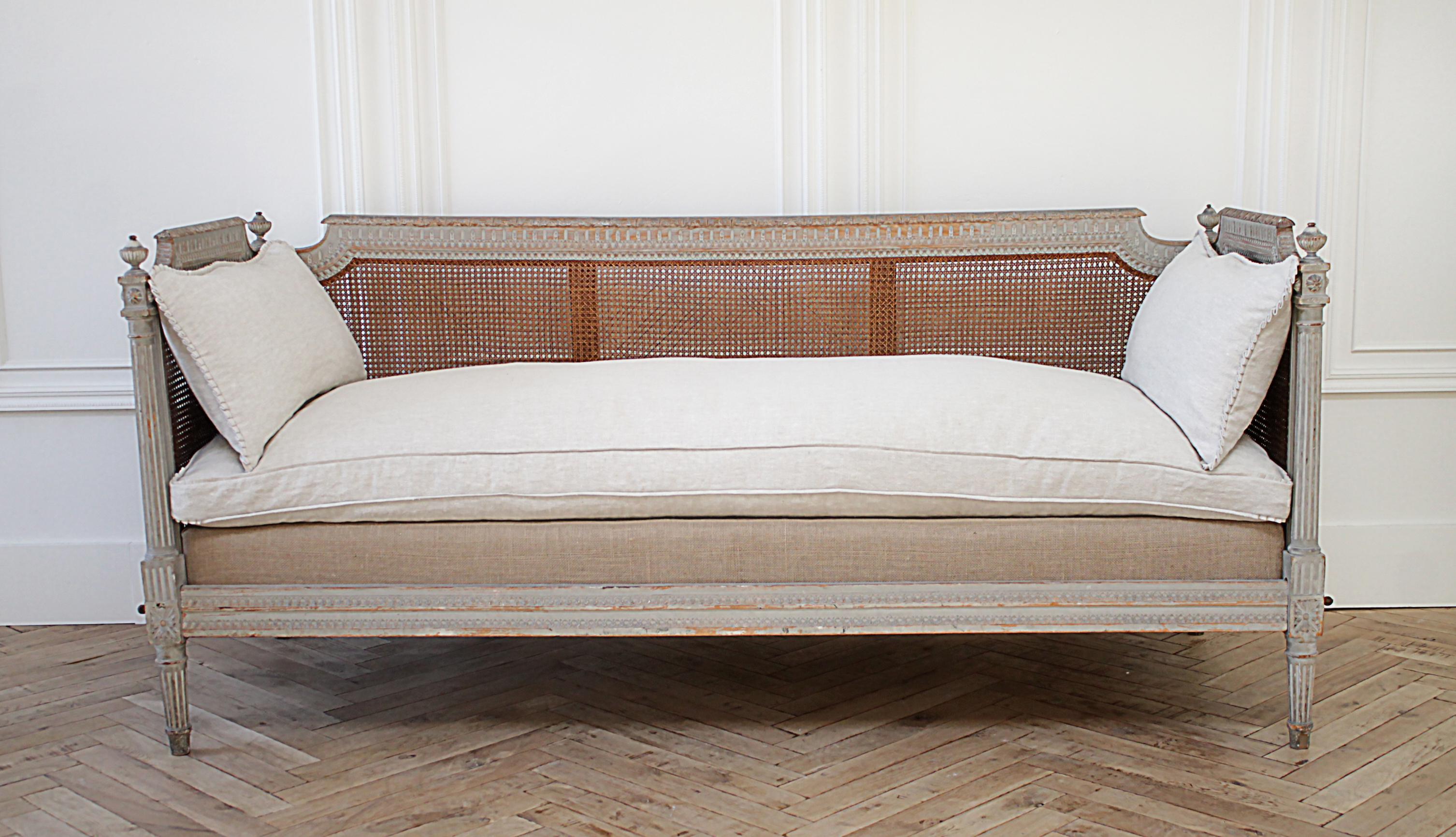 19th century carved and original painted Louis XVI style cane daybed
painted in a light French gray color, which is original, it has a wonderful aged distressed patina. With natural wood tones showing through and antique patina. The cane is