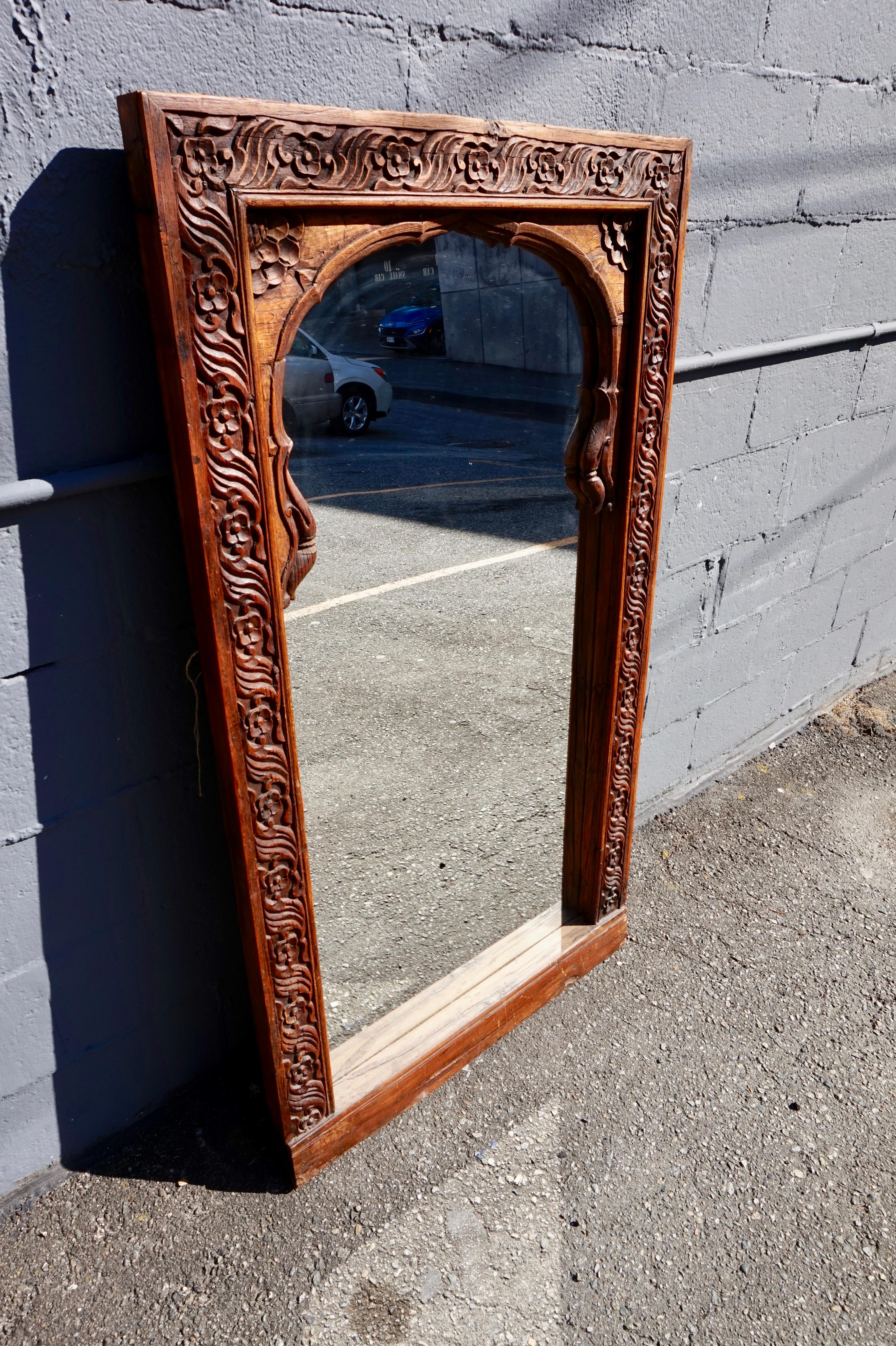 Circa 1880's

Indian arched window converted into a mirror. Solid teak frame laced with floral motif carvings. Hard backed and wired for hanging or can be used as a wall mirror. Good original patina.