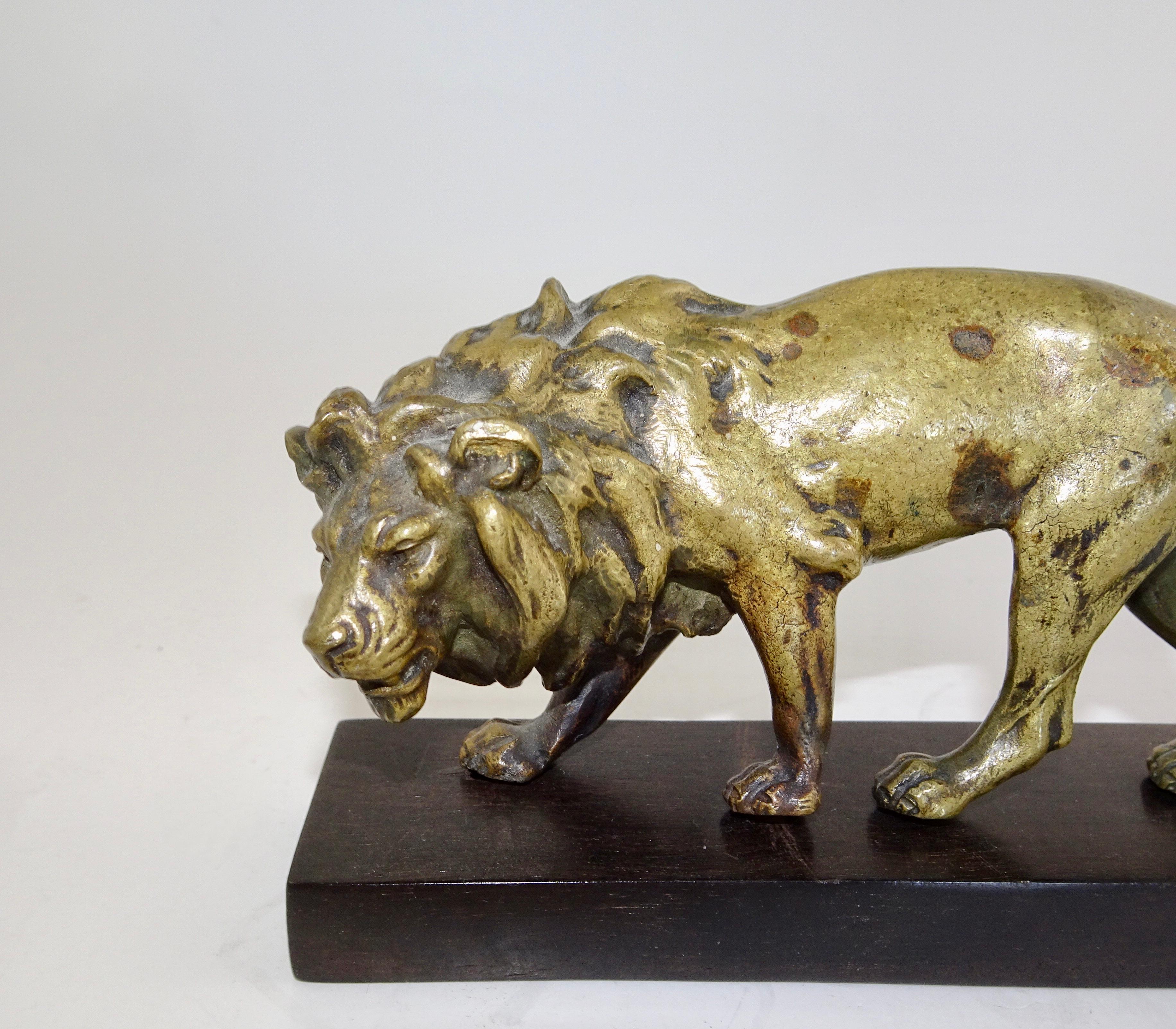 Carved bronze statue of lion on wooden base from the 19th century.