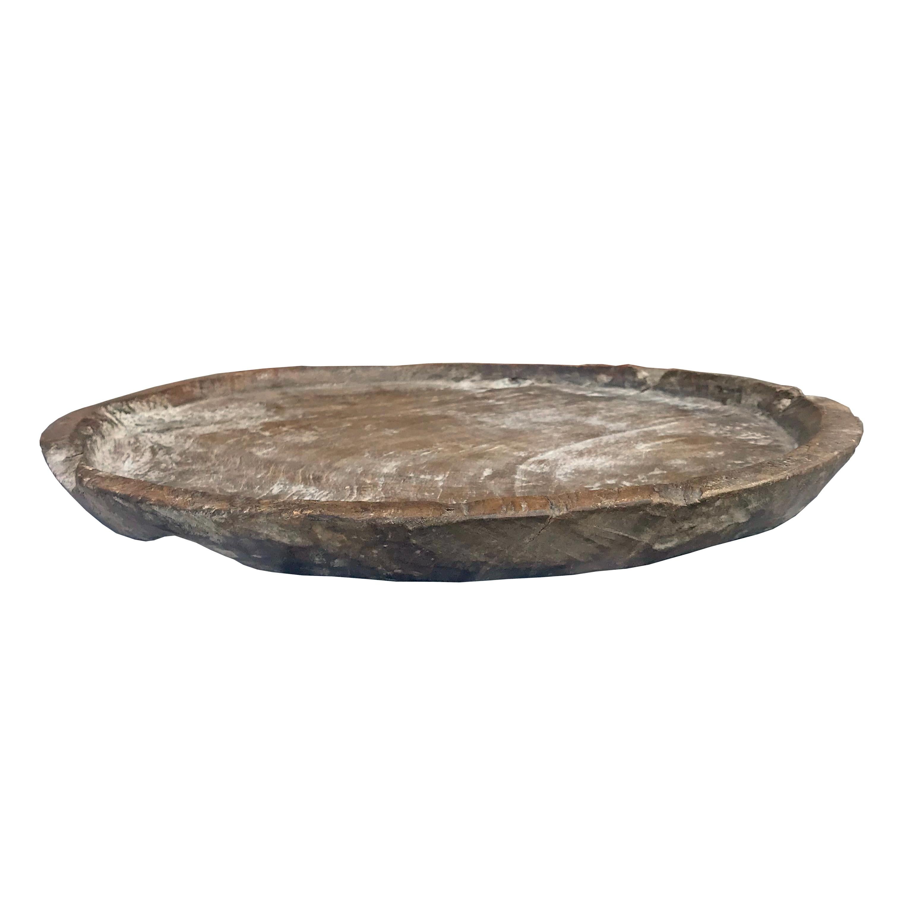 An incredible 19th century carved burl wood tray with a rustic live edge with shallow lip, a well worn finish, and a small hole at one side. The finish on this piece is amazing!