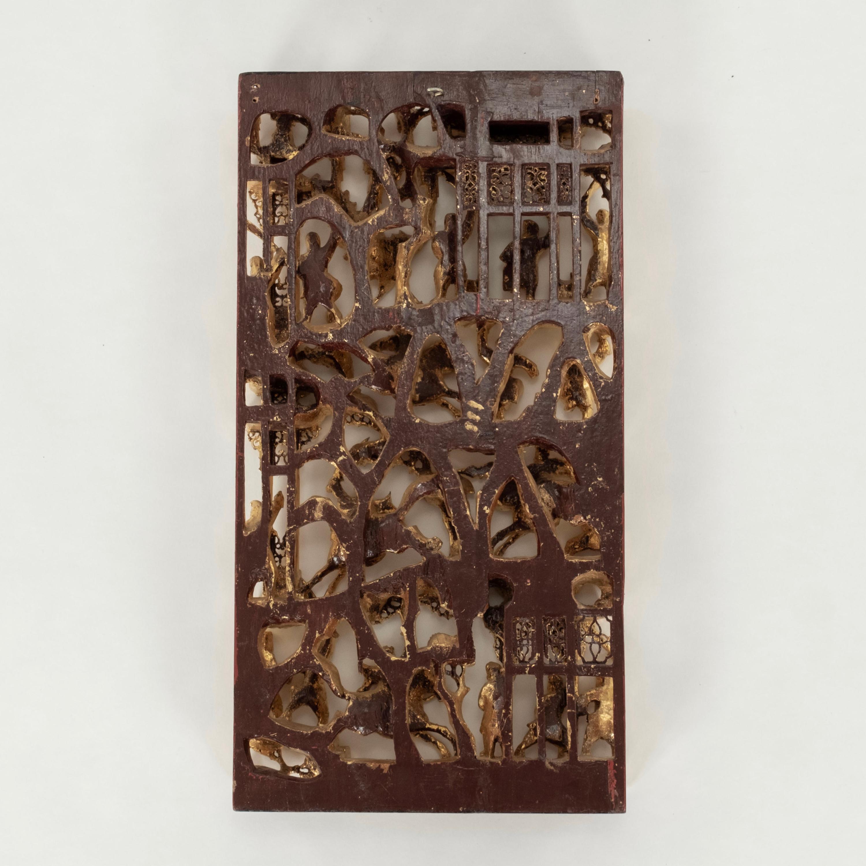 Panneau chinois du XIXe siècle en bois sculpté à la main et doré représentant une scène de bataille avec des guerriers debout et à cheval tirant des épées, engagés dans un combat et chargeant avec des bannières levées.