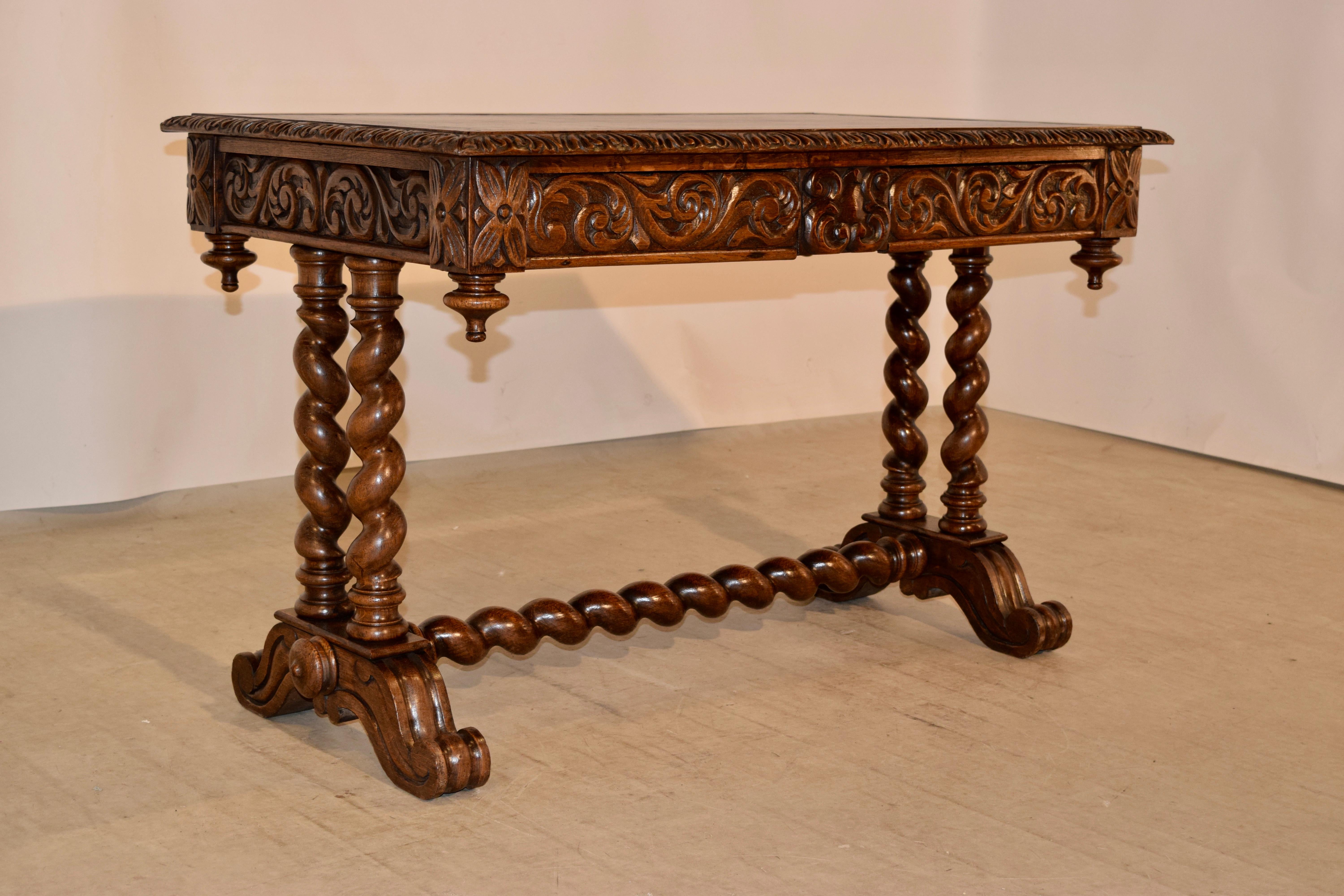 19th century hand carved oak desk from France with a leather top with a hand tooled gilt border and a banded border and a bevelled and hand carved decorated edge. This follows down to a hand carved apron on all four sides for easy placement in a
