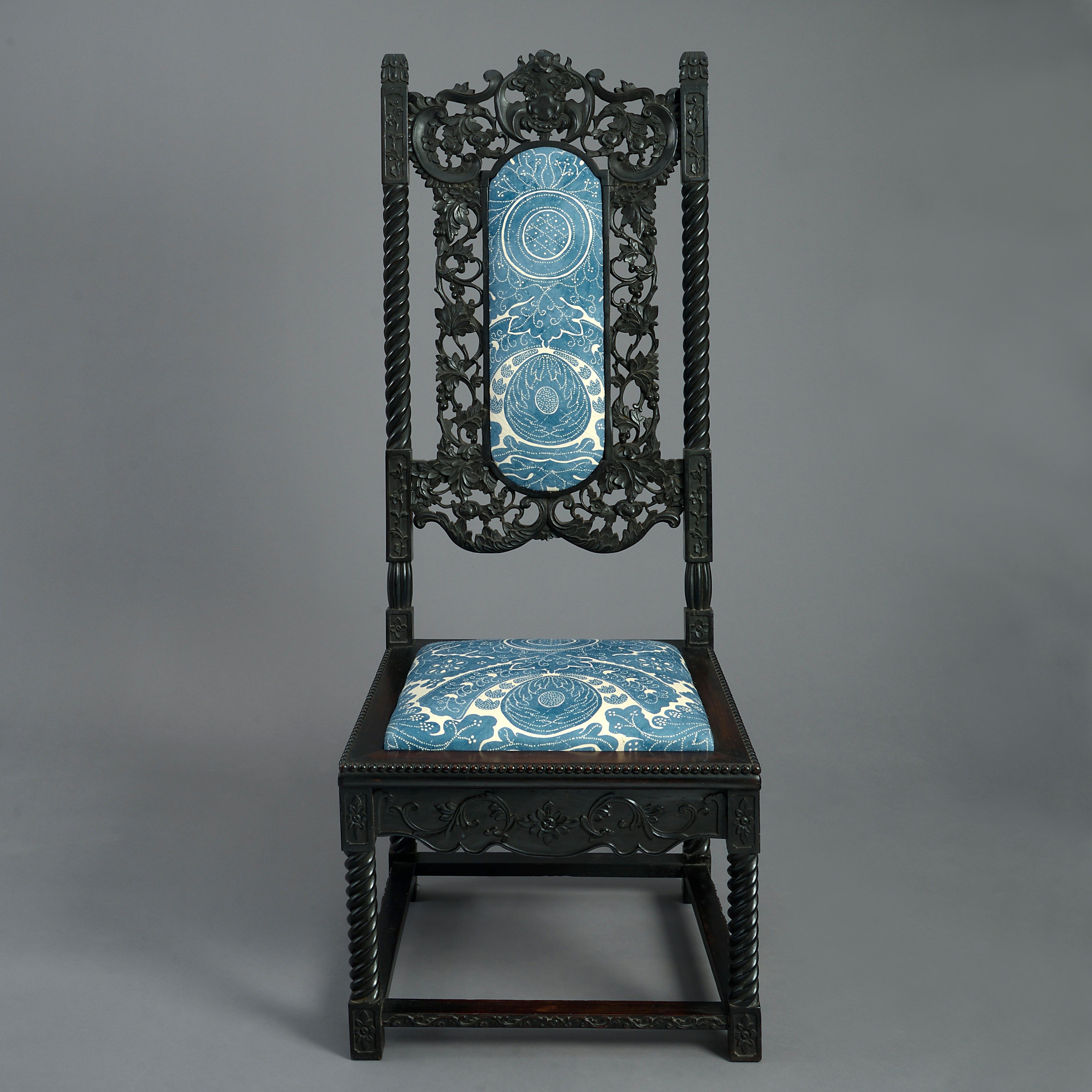 A late nineteenth century ebony high back side chair, with richly carved floral motifs throughout, the seat and back supports with barley twists and having an upholstered pad and drop-in seat.

 