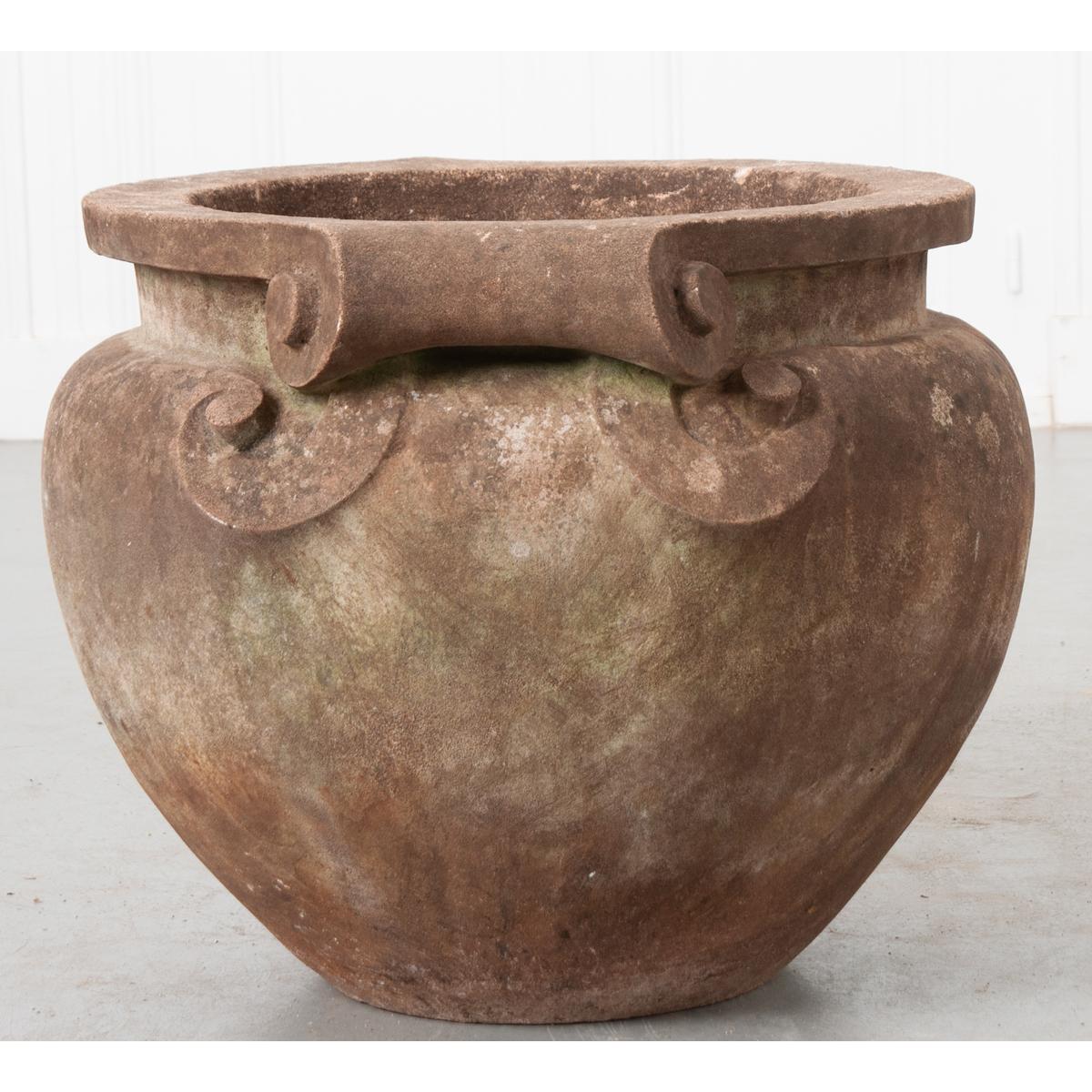 Nous sommes tellement intrigués par la taille et le design de ce merveilleux pot en pierre ancien. Nous aimons le design simulé avec les poignées en forme de volutes et la couleur de la pierre. Ce pot fonctionnerait aussi bien à l'intérieur qu'à
