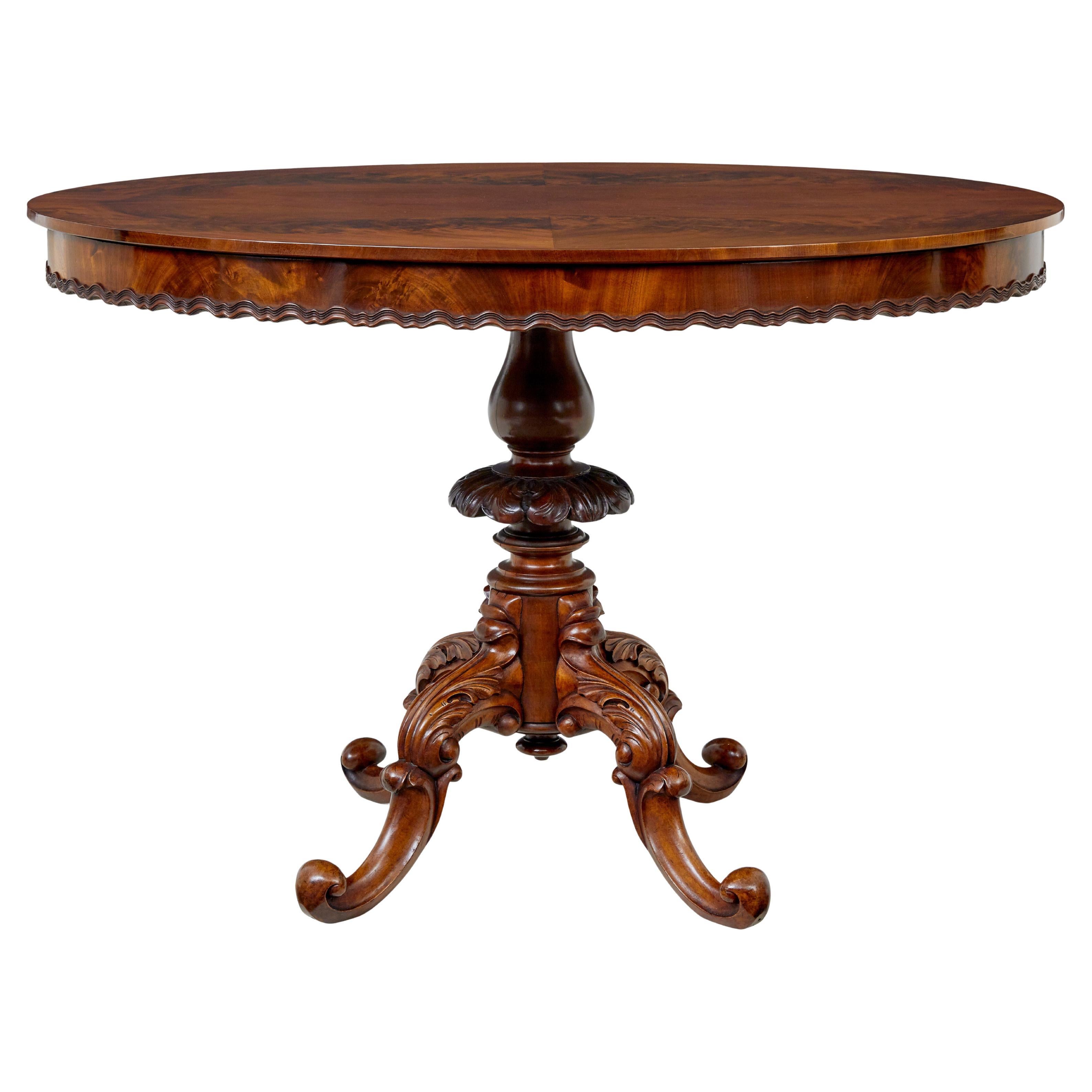 Table centrale ovale en acajou flammé sculpté du 19e siècle