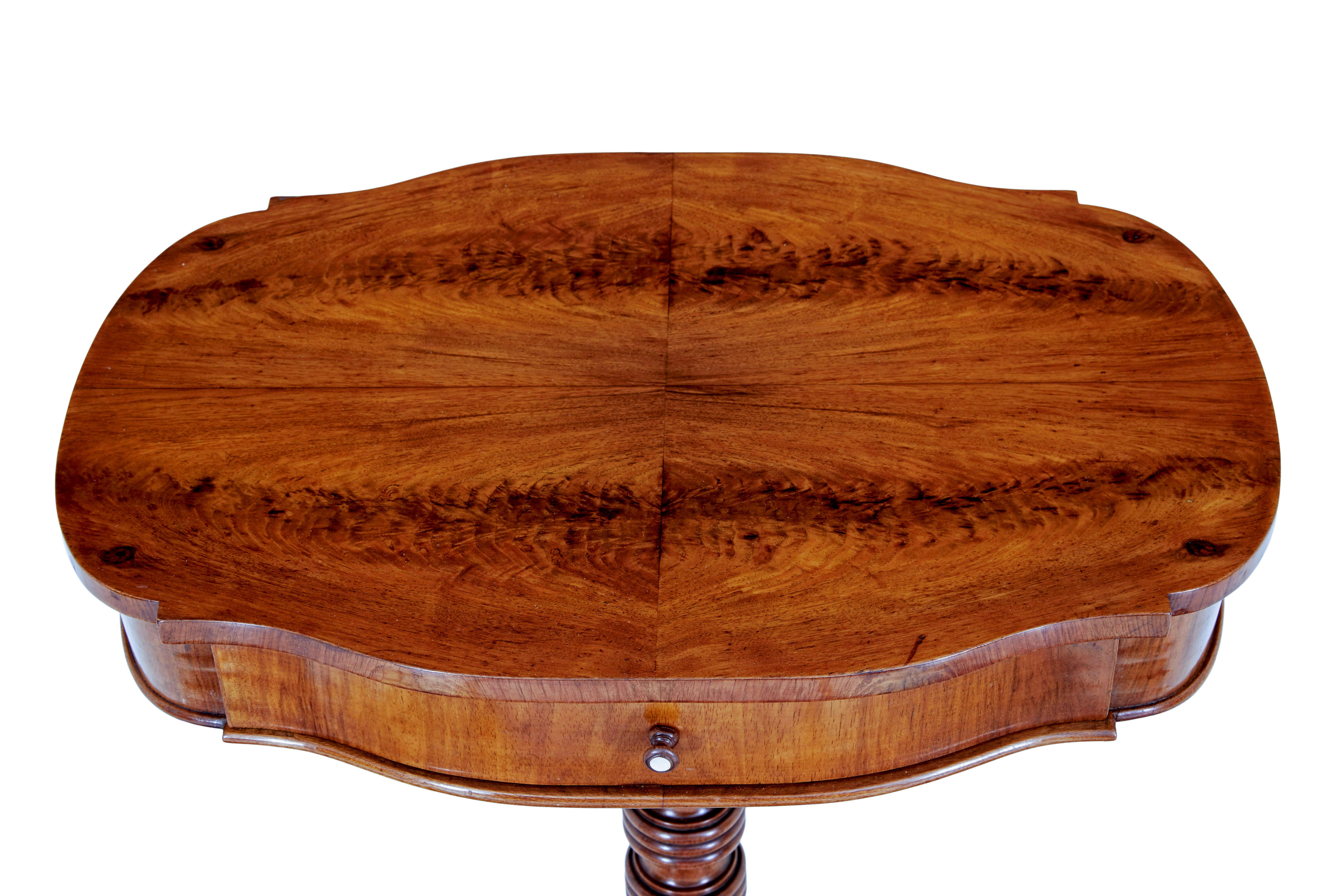 Table d'appoint en acajou flammé sculpté du 19e siècle vers 1890.

Plateau façonné de haute qualité avec placages d'acajou flammé assortis.  Tiroir unique pour le rangement.  Le support de colonne tourné est relié aux 4 pieds sculptés à