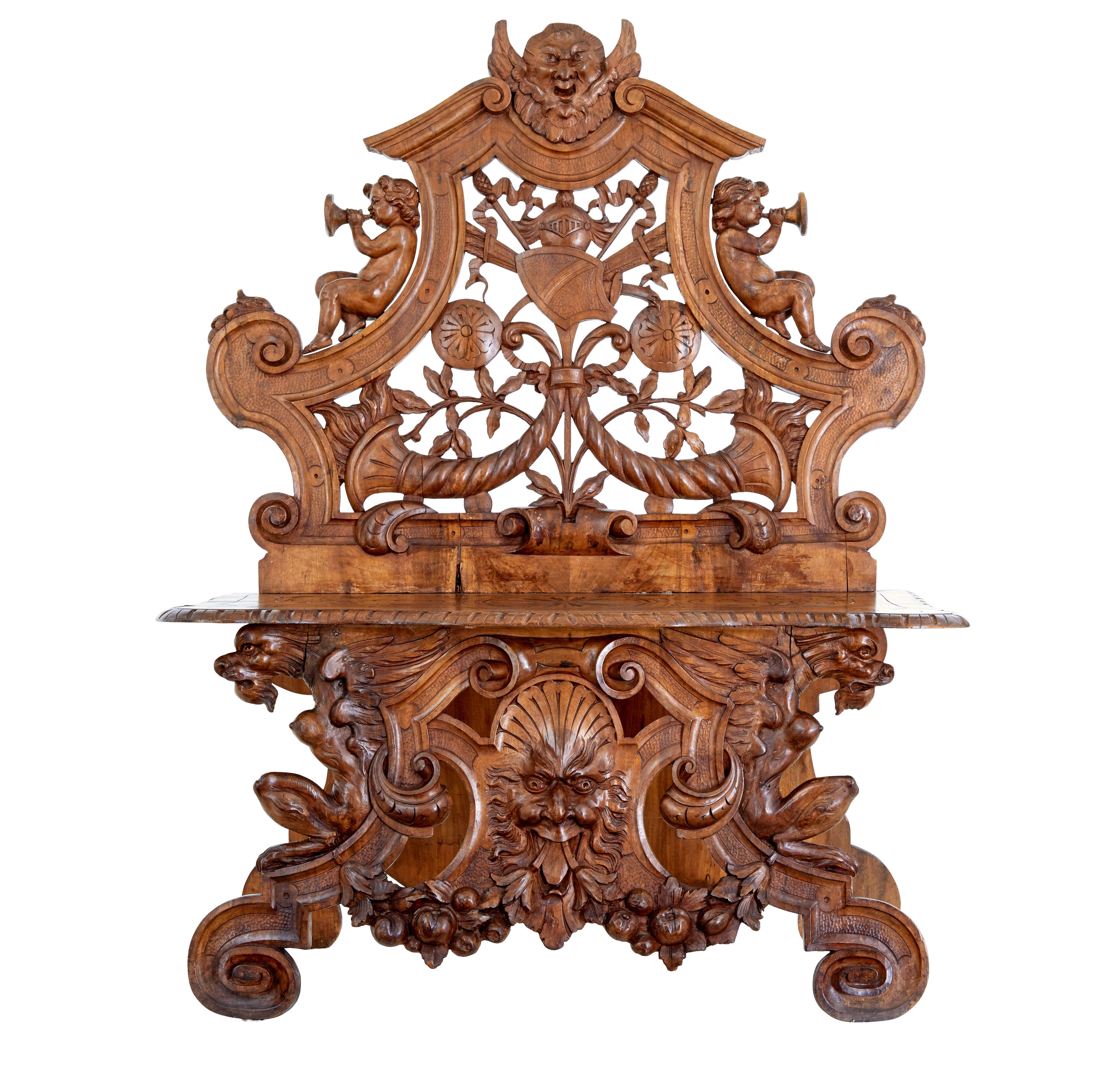Chaise décorative en noyer flamand du 19e siècle, fortement sculptée, vers 1890.

Dossier sculpté d'une tête mythique, d'angelots, d'un motif armorié et d'une corne d'abondance.  L'assise est sculptée.  Les pieds avant sont ornés de griffons