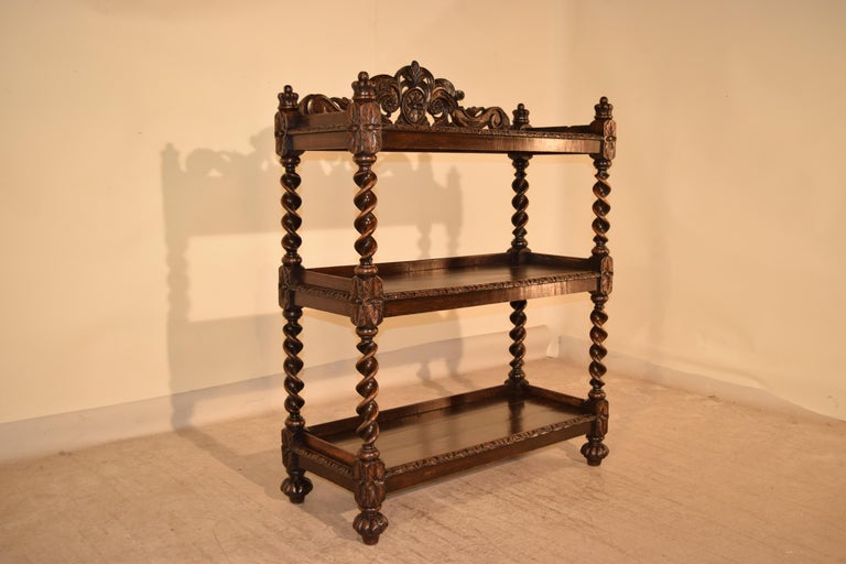 19th century French oak dessert buffet with three tiers and fantastic carvings adorning the top and sides. The finials on top are crowns, and the shelf supports are unusual vine twists. Lovely carved edges on shelves and carved turned feet with