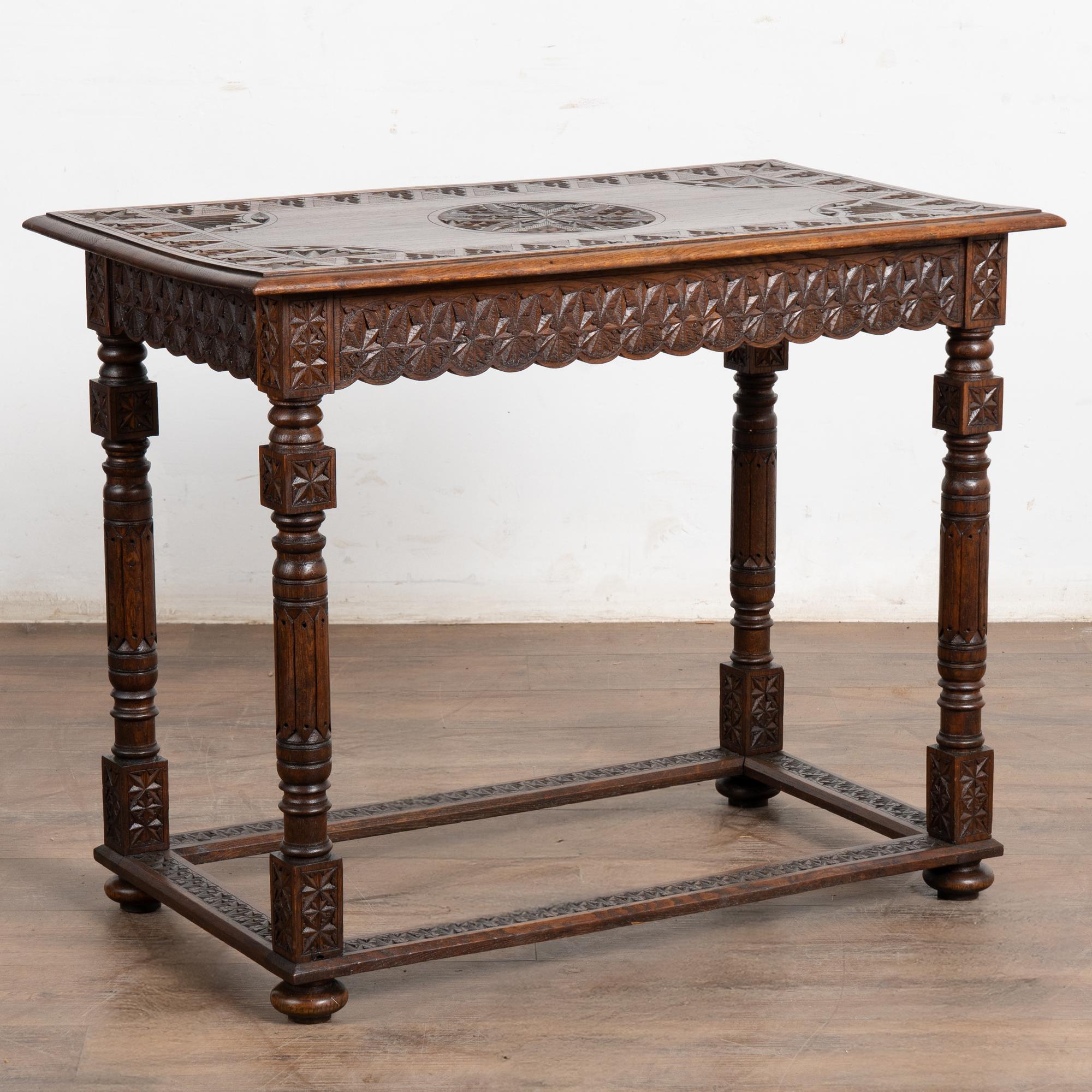 La profunda pátina de la madera de roble envejecida atrae a esta bonita mesa auxiliar procedente de Francia, que también puede servir como mesilla de noche o pequeña consola.
Abundan las tallas decorativas en la parte superior, el faldón, las patas