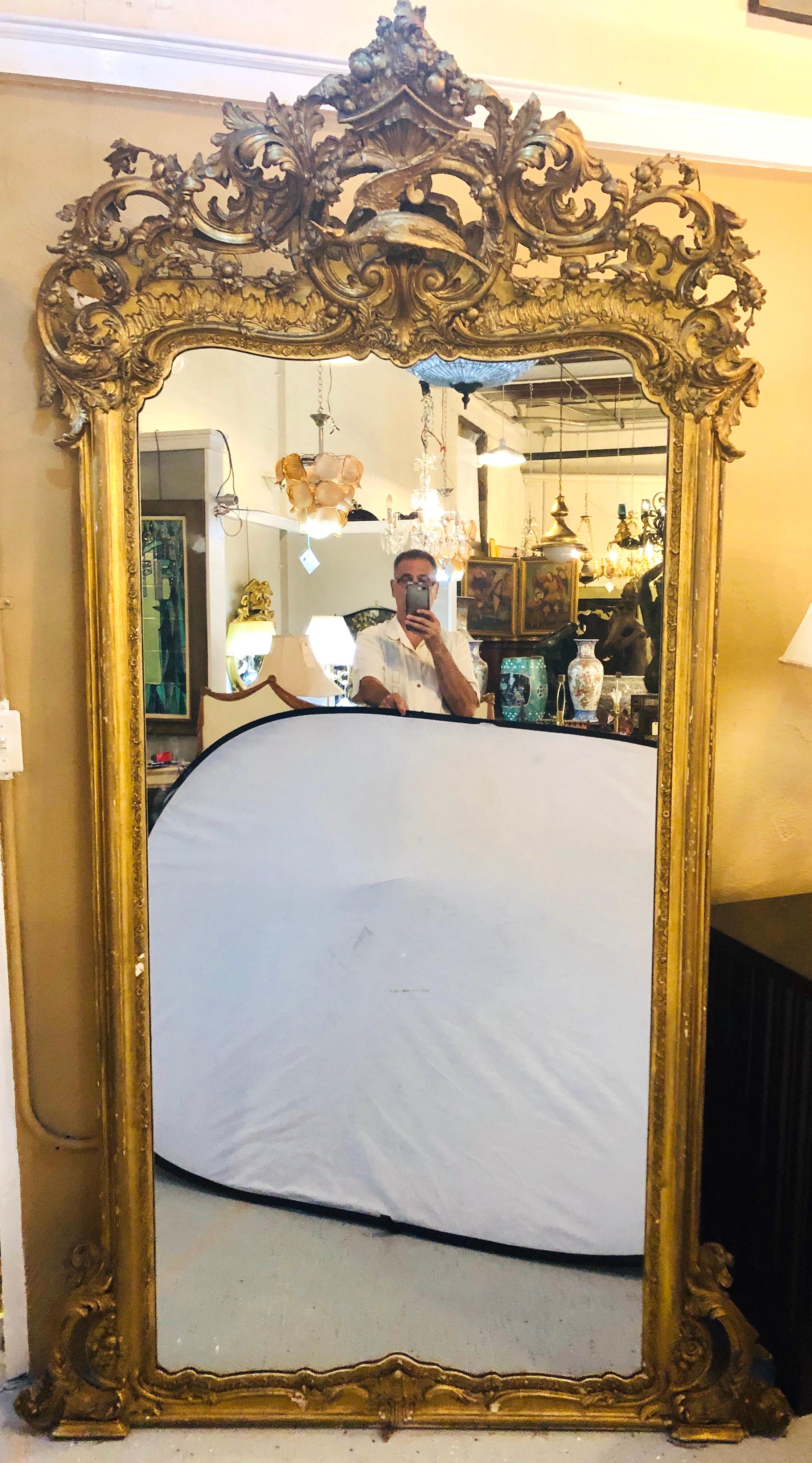 An enormous monumental 19th century carved gilt gold pier, console, floor, full length or over the mantle mirror. This simply stunning heavily carved floor, pier, console or over the mantle mirror is one of a kind. Having taken this mirror down from
