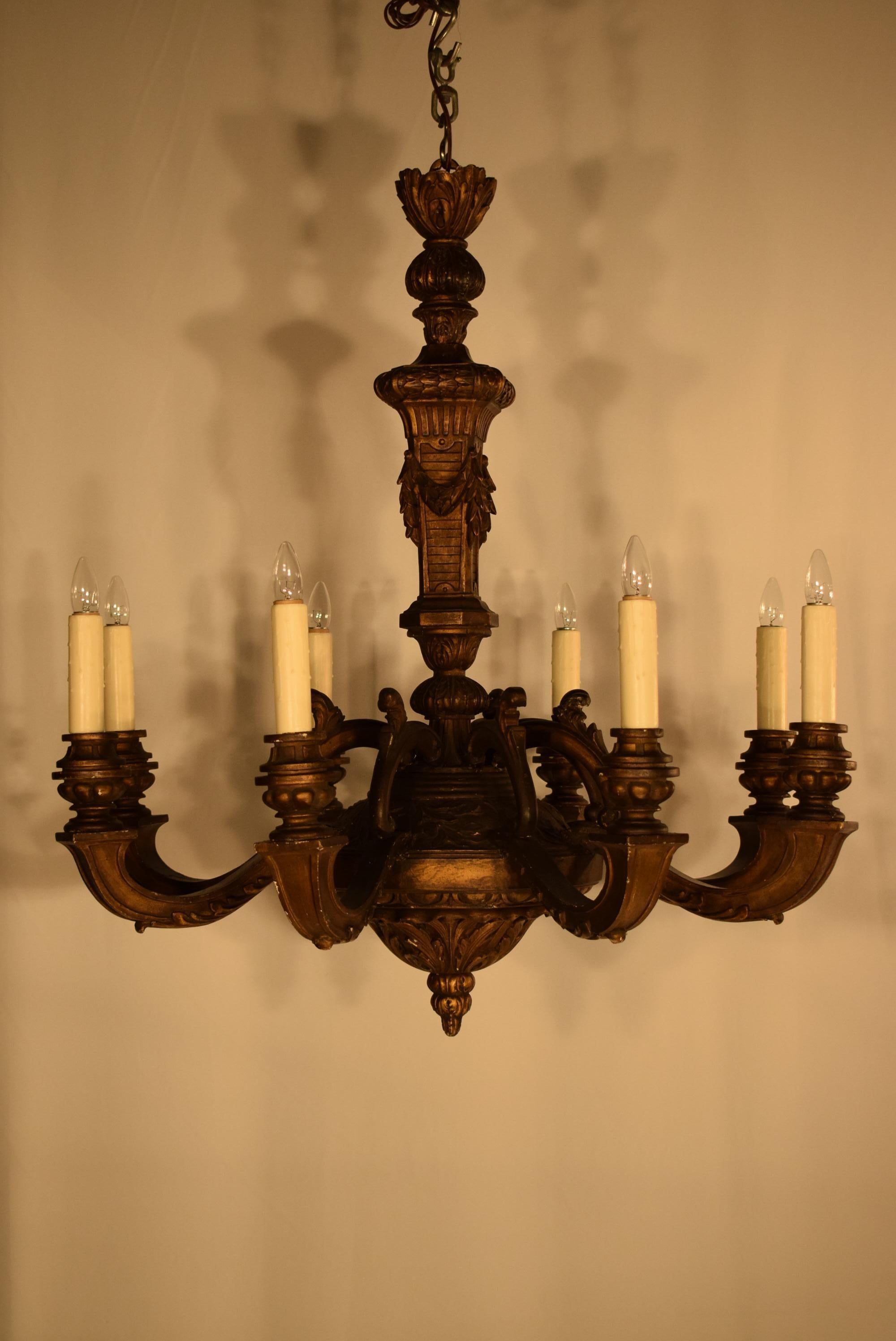 A very fine carved giltwood chandelier in the Louis XIV style. Central shaft featuring carved square column ornate with garlands. Square section arms featuring elaborate candle cup and a graceful acanthus leaf on their underside. France, circa 1910.