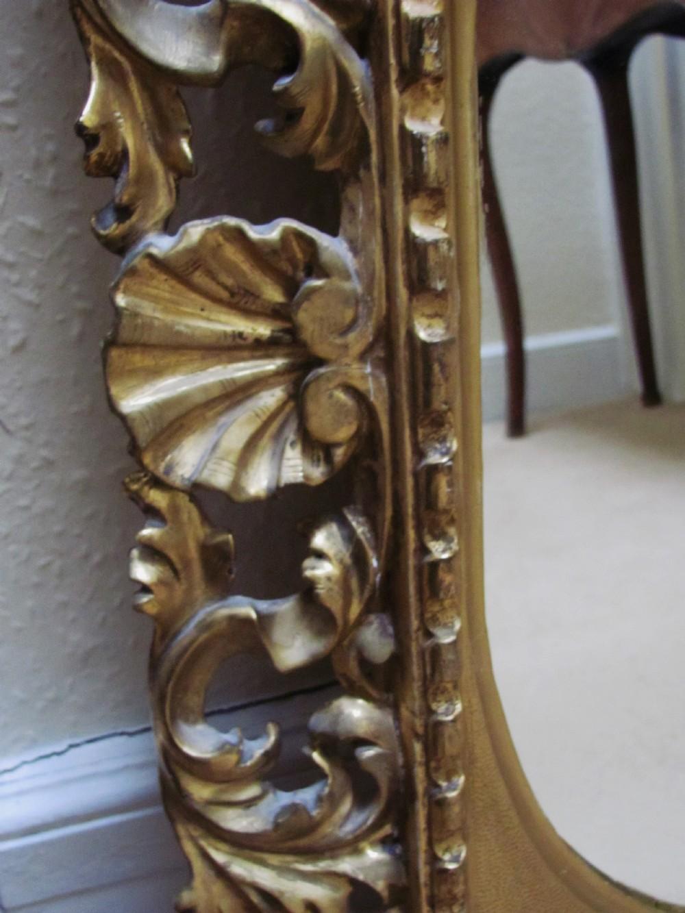 italien Miroir ovale à encadrement Florentine en bois sculpté et doré du 19ème siècle en vente