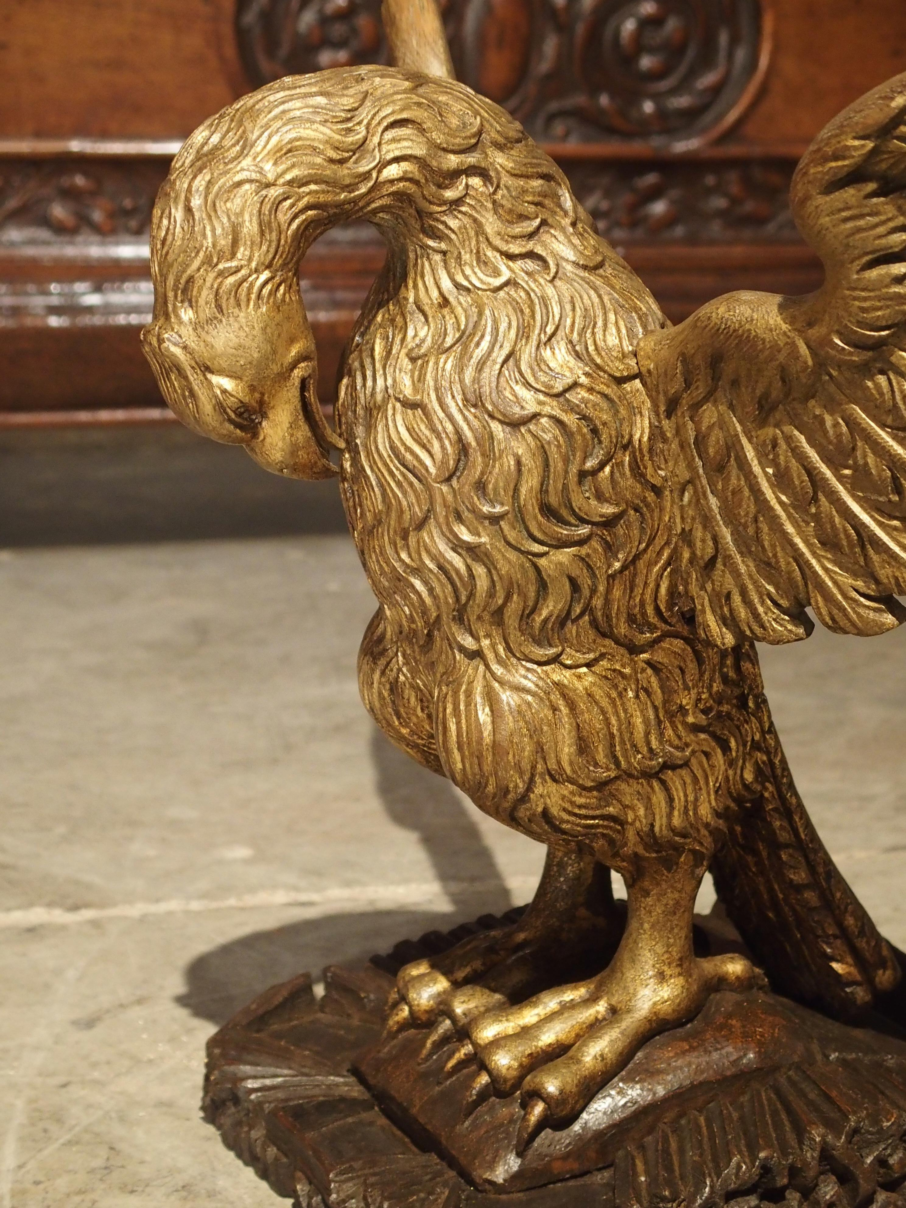Beautifully and artistically shaped, this giltwood hand carved eagle on stand is from Europe. In ancient Rome, the Eagle came to symbolize power and strength. This eagle, with its outstretched wings is resting upon a carved wooden base. His position